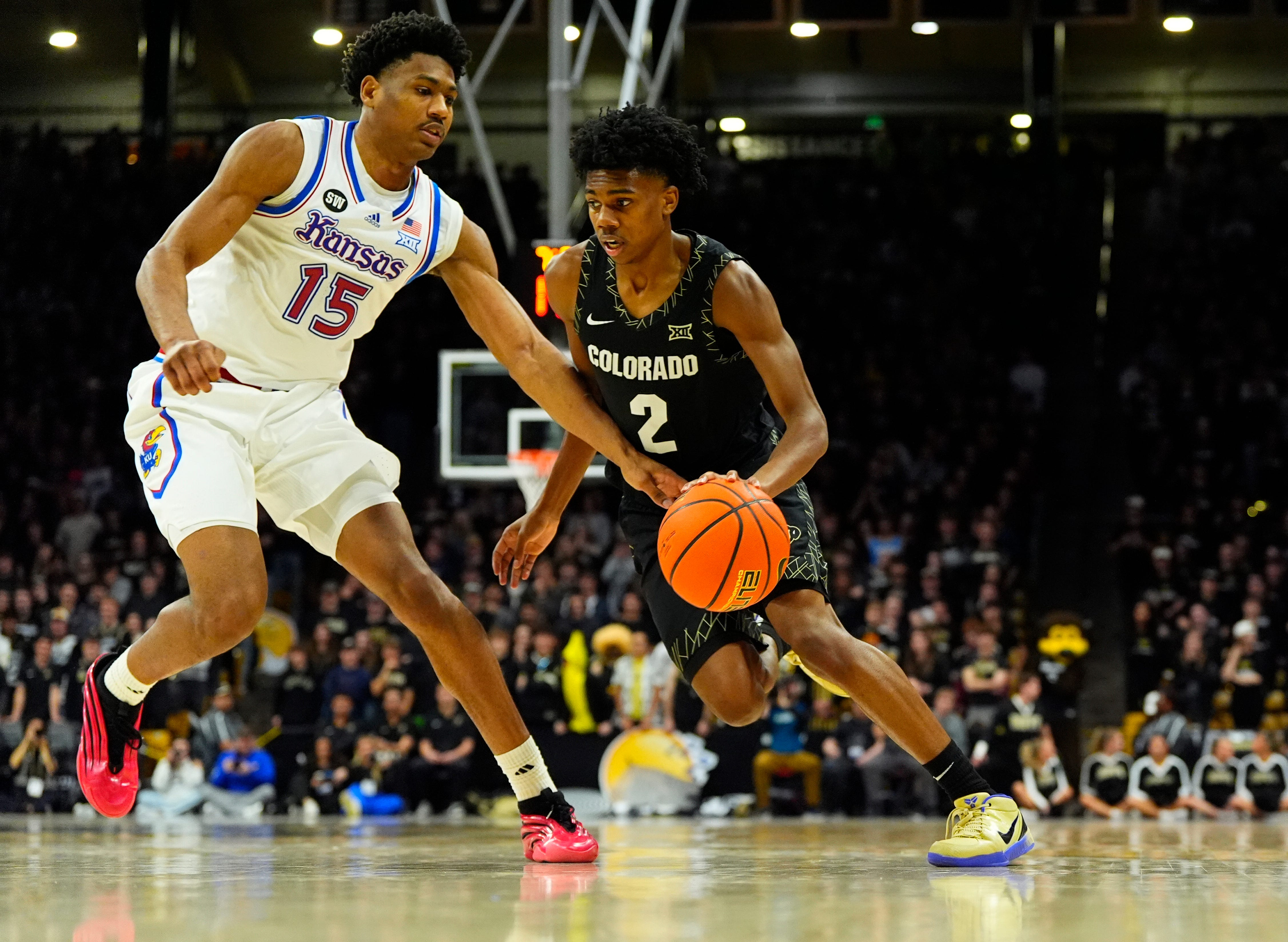 Jan 20, 2026; Boulder, Colorado, USA; Colorado Buffaloes guard Isaiah Johnson (2) drives at Kansas Jayhawks forward Bryson Tiller (15) in the second half at the CU Events Center. Mandatory Credit: Ron Chenoy-Imagn Images