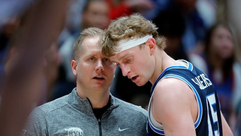 BYU head coach Kevin Young, left, talks with guard Richie Saunders during game against Kansas, Saturday, Jan. 31, 2026, in Lawrence, Kan. Next up for BYU is a game against Oklahoma State Wednesday in Stillwater.