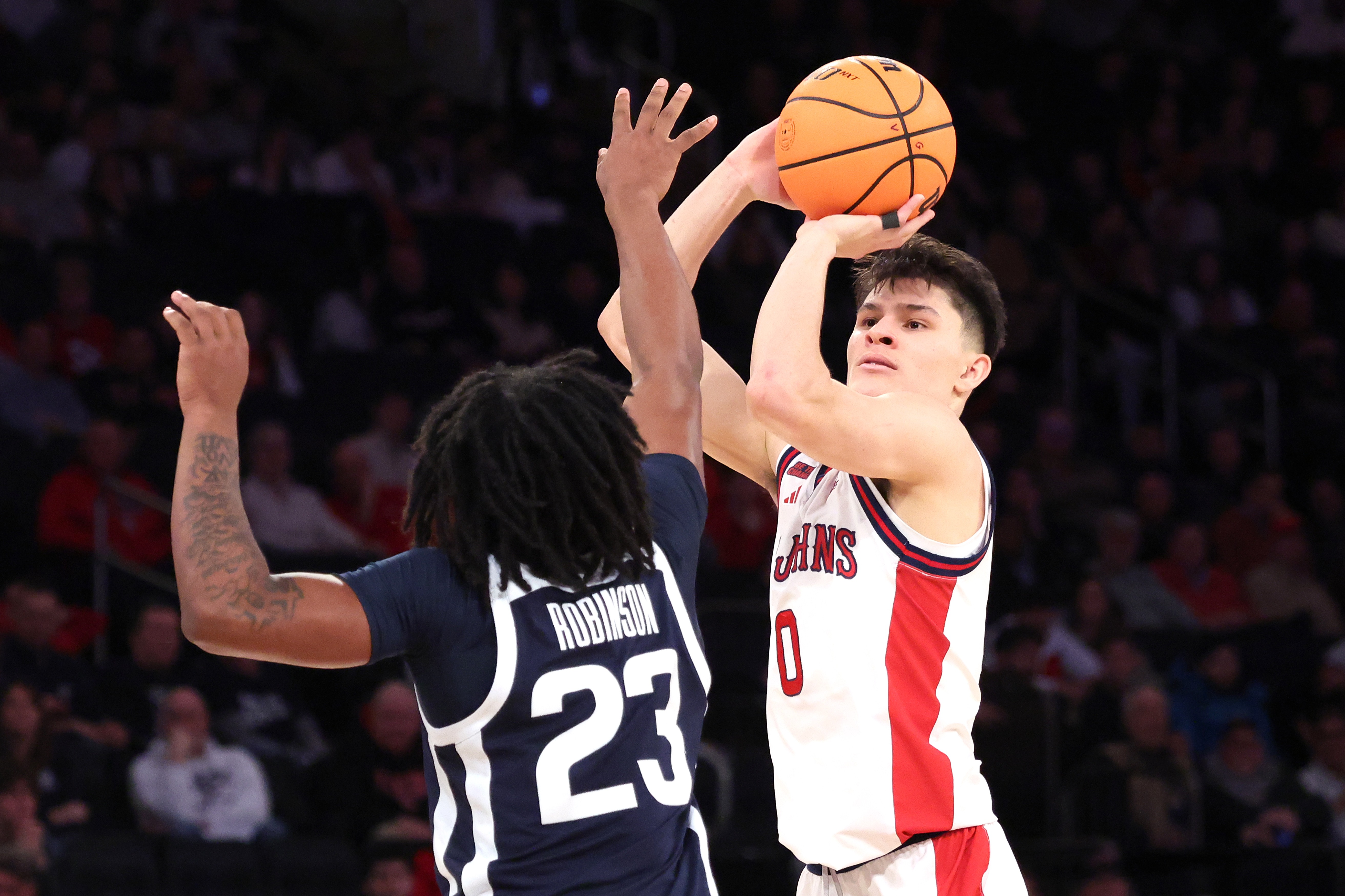 St. John's Red Storm guard Dylan Darling #0 puts up a shot as Butler Bulldogs guard Azavier Robinson #23 defends during the second half. The St. John's Red Storm defeated the Butler Bulldogs 92-70.