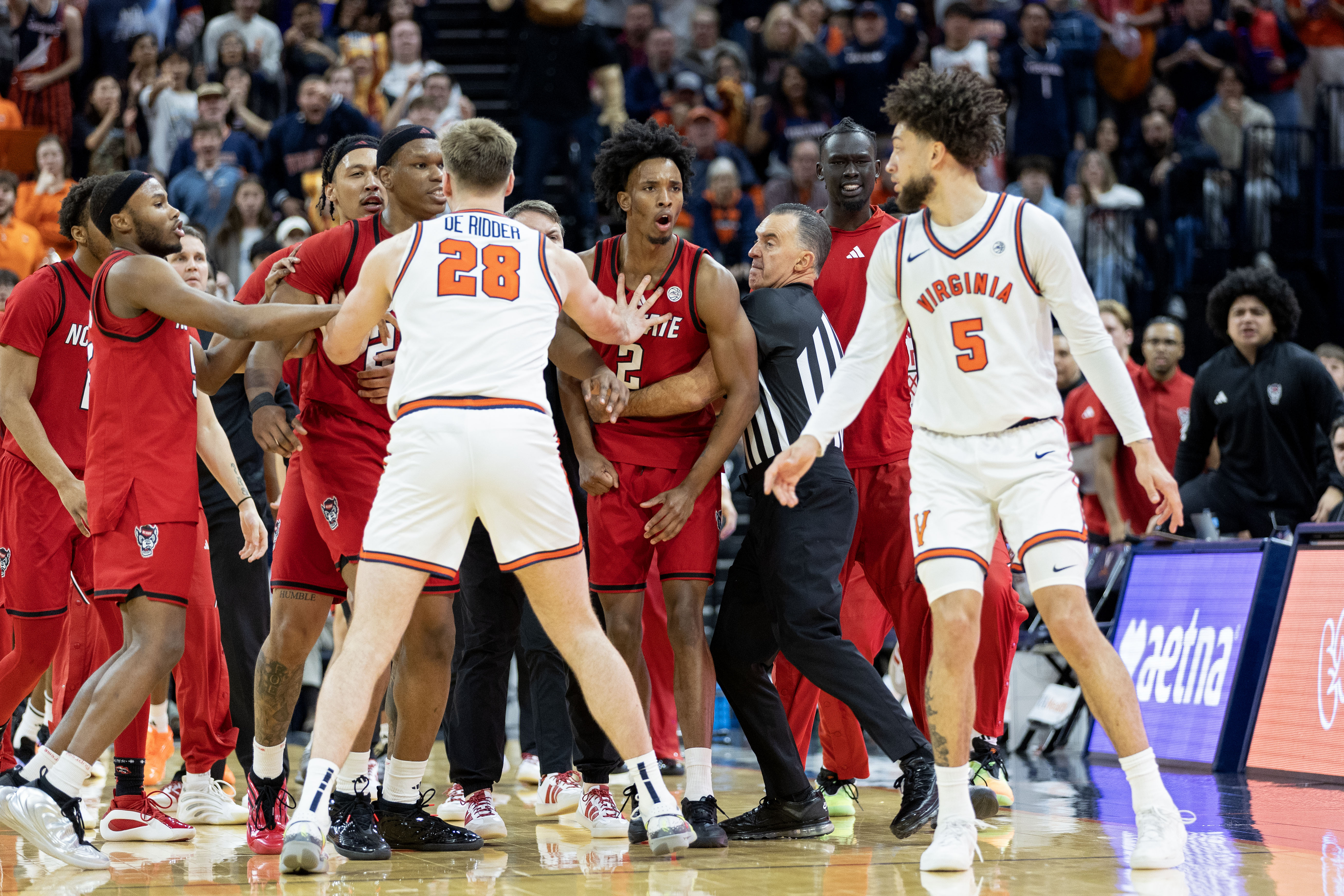 CHARLOTTESVILLE, VIRGINIA - FEBRUARY 24: Referee Roger Ayers holds back Paul McNeil, Jr. #2 of the NC State Wolfpack as he shouts at Sam Lewis #5 of the Virginia Cavaliers during a scuffle in the second half during the game at John Paul Jones Arena on February 24, 2026 in Charlottesville, Virginia.  (Photo by Ryan M. Kelly/Getty Images)