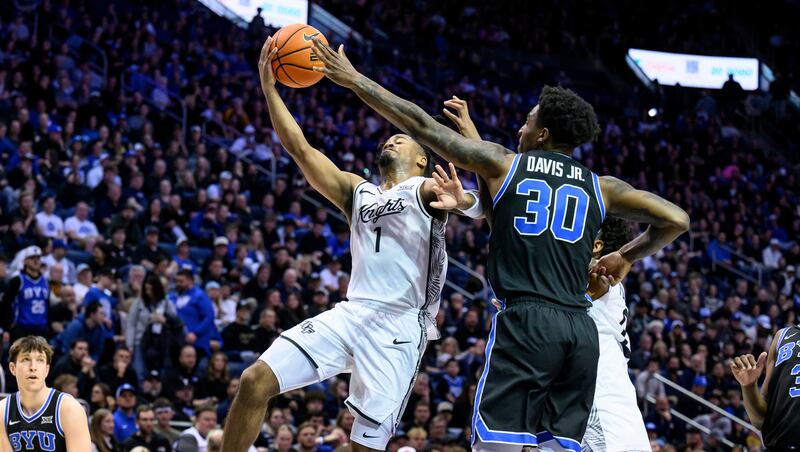 UCF guard Themus Fulks (1) goes to the basket for a layup guarded by BYU guard Kennard Davis Jr. (30) during the second half of an NCAA college basketball game, Tuesday, Feb. 24, 2026, in Provo, Utah.