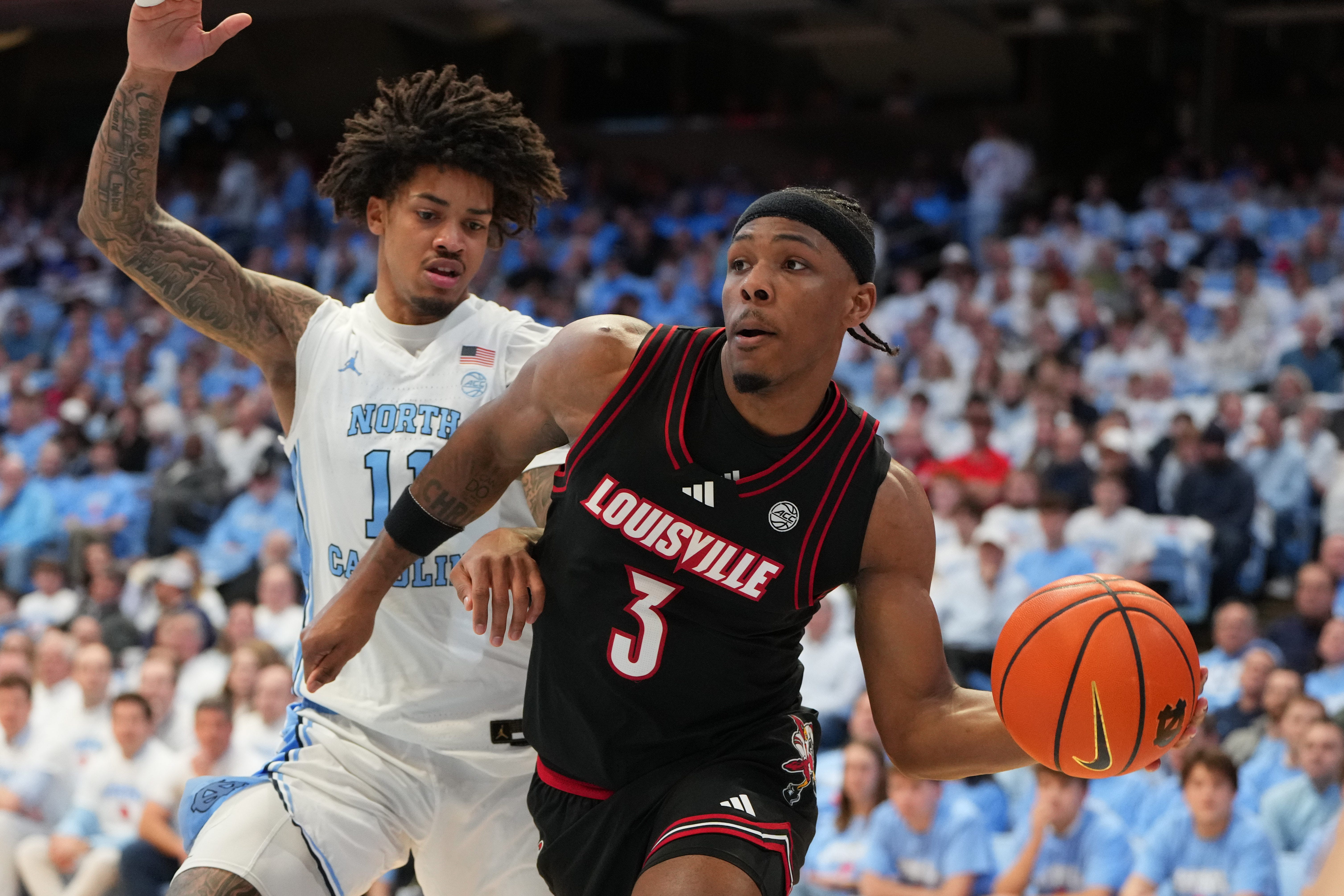 Feb 23, 2026; Chapel Hill, North Carolina, USA; Louisville Cardinals guard Ryan Conwell (3) passes the ball as North Carolina Tar Heels forward Jonathan Powell (11) defends in the first half at Dean E. Smith Center. Mandatory Credit: Bob Donnan-Imagn Images