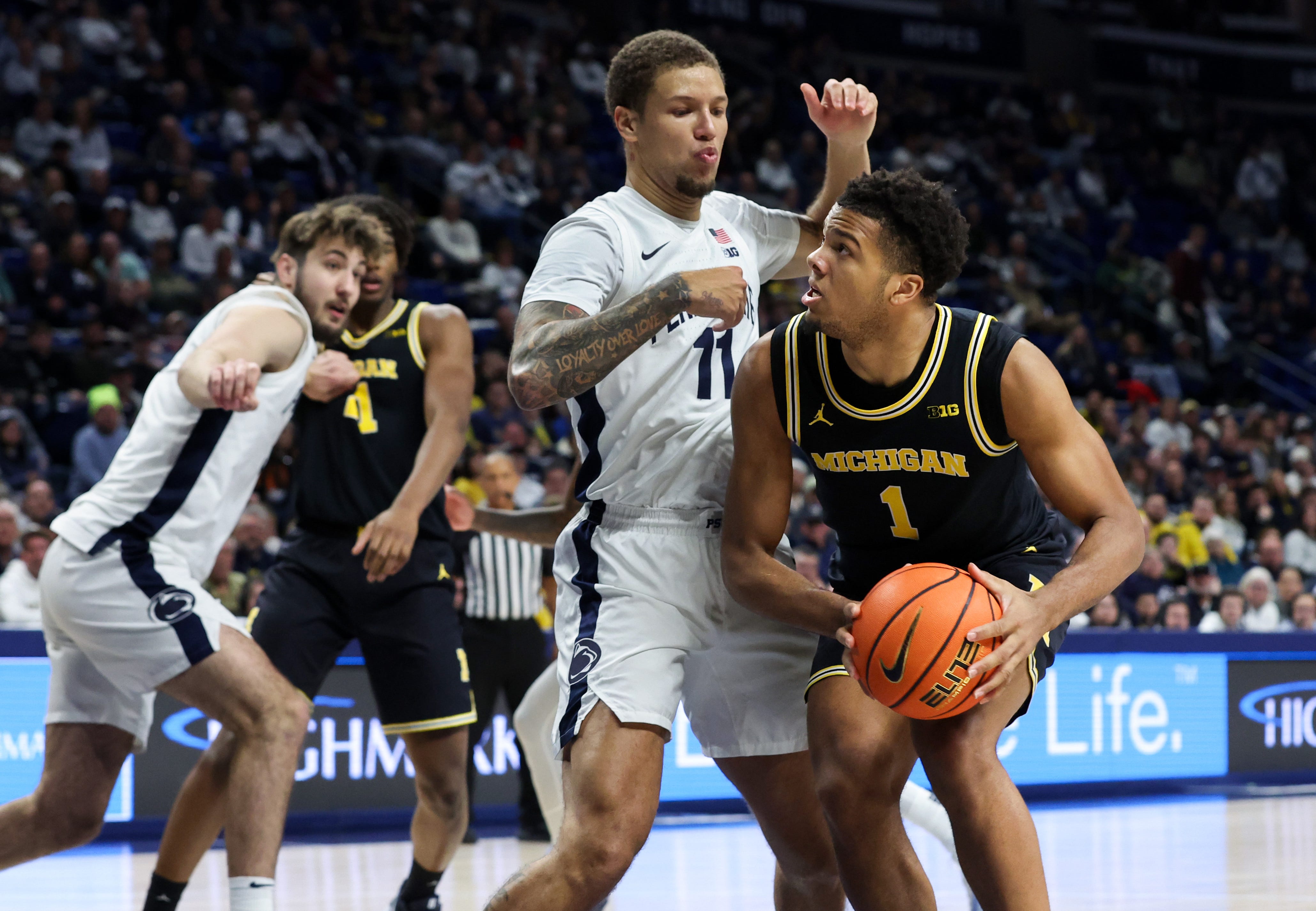 Jan 6, 2026; University Park, Pennsylvania, USA; Michigan guard Trey McKenney (1) looks for a way to the basket as Penn State Nittany Lions guard Eli Rice (11) defends during the second half at Bryce Jordan Center. Mandatory Credit: Matthew O'Haren-Imagn Images
