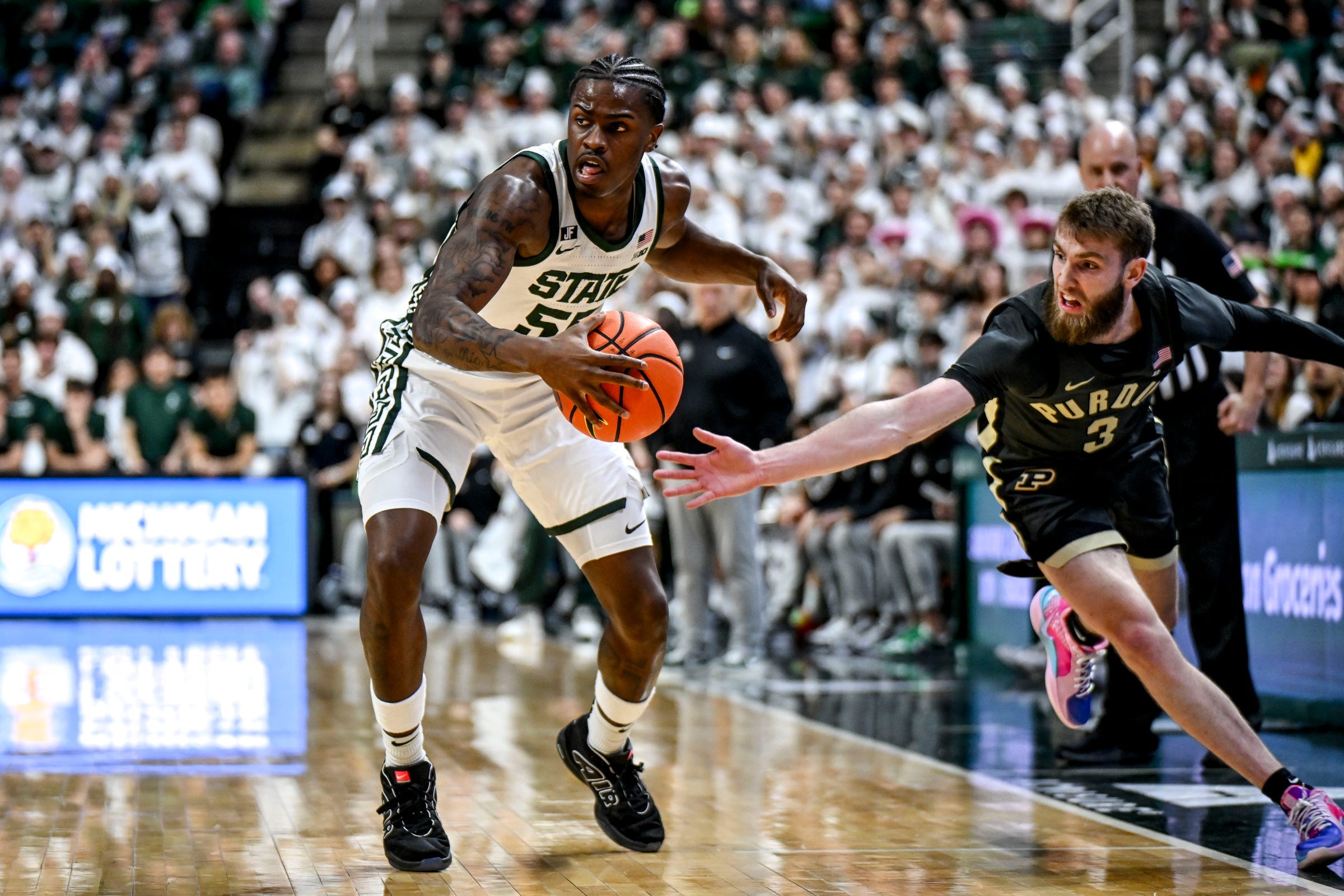 Michigan State's Coen Carr, left, moves the ball as Purdue's Braden Smith closes in during the first half on Tuesday, Feb. 18, 2025, at the Breslin Center in East Lansing.