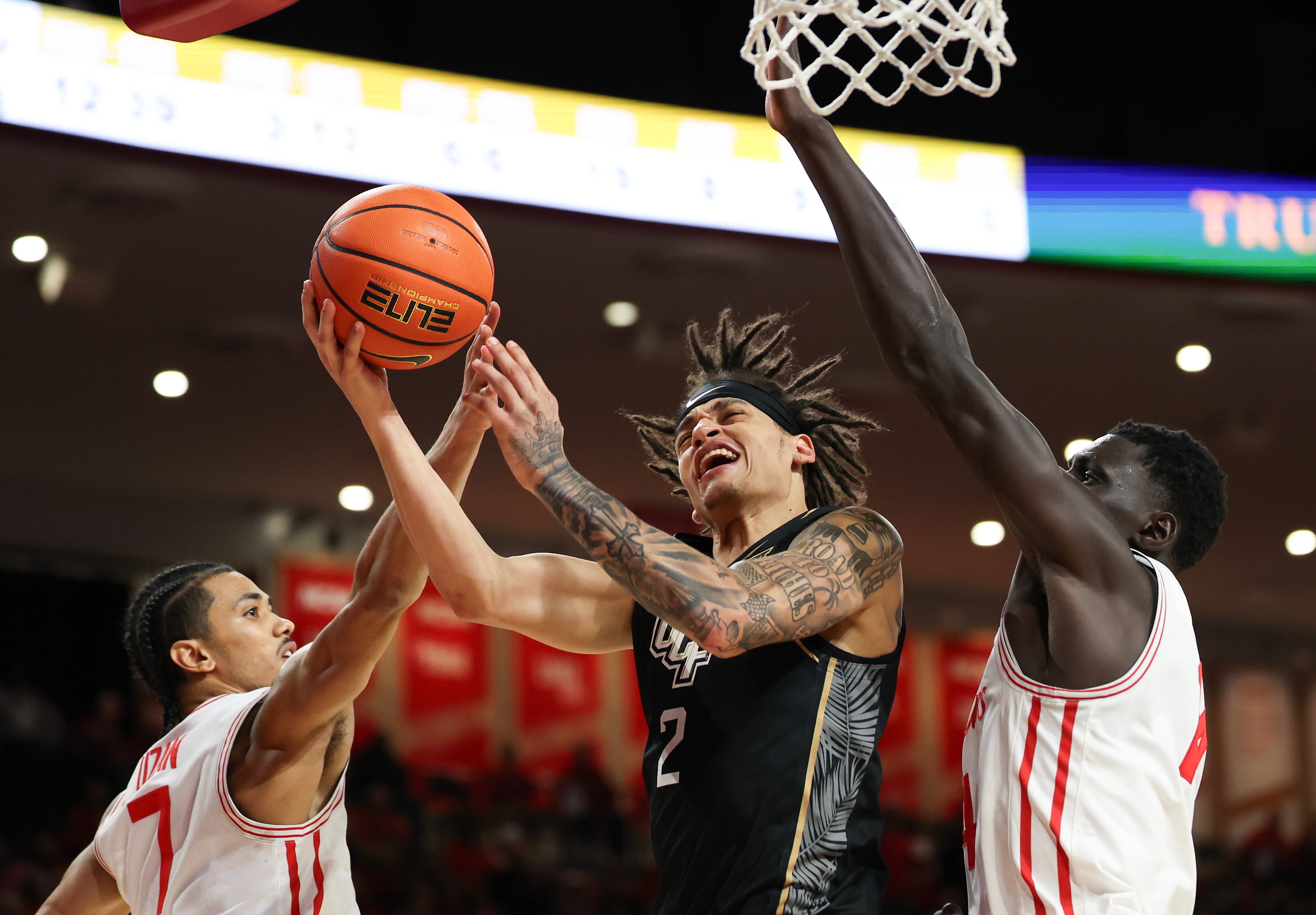 Feb 4, 2026; Houston, Texas, USA; UCF Knights guard Riley Kugel (2) splits the defense of Houston Cougars guard Milos Uzan (7) and forward Kalifa Sakho (14) in the second half at Fertitta Center. Mandatory Credit: Thomas Shea-Imagn Images
