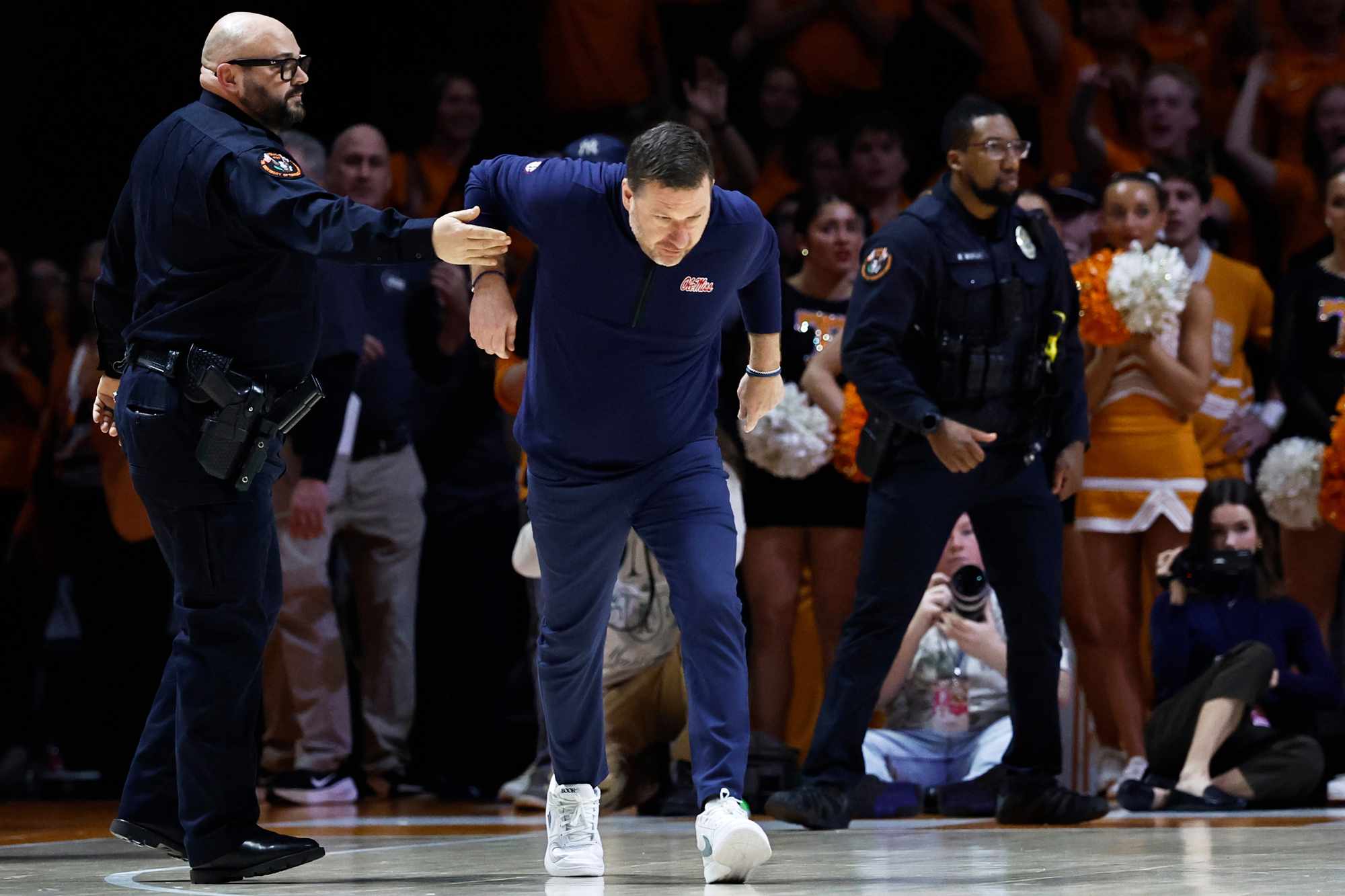 An officer tries to restrain Mississippi head coach Chris Beard AP Photo/Wade Payne