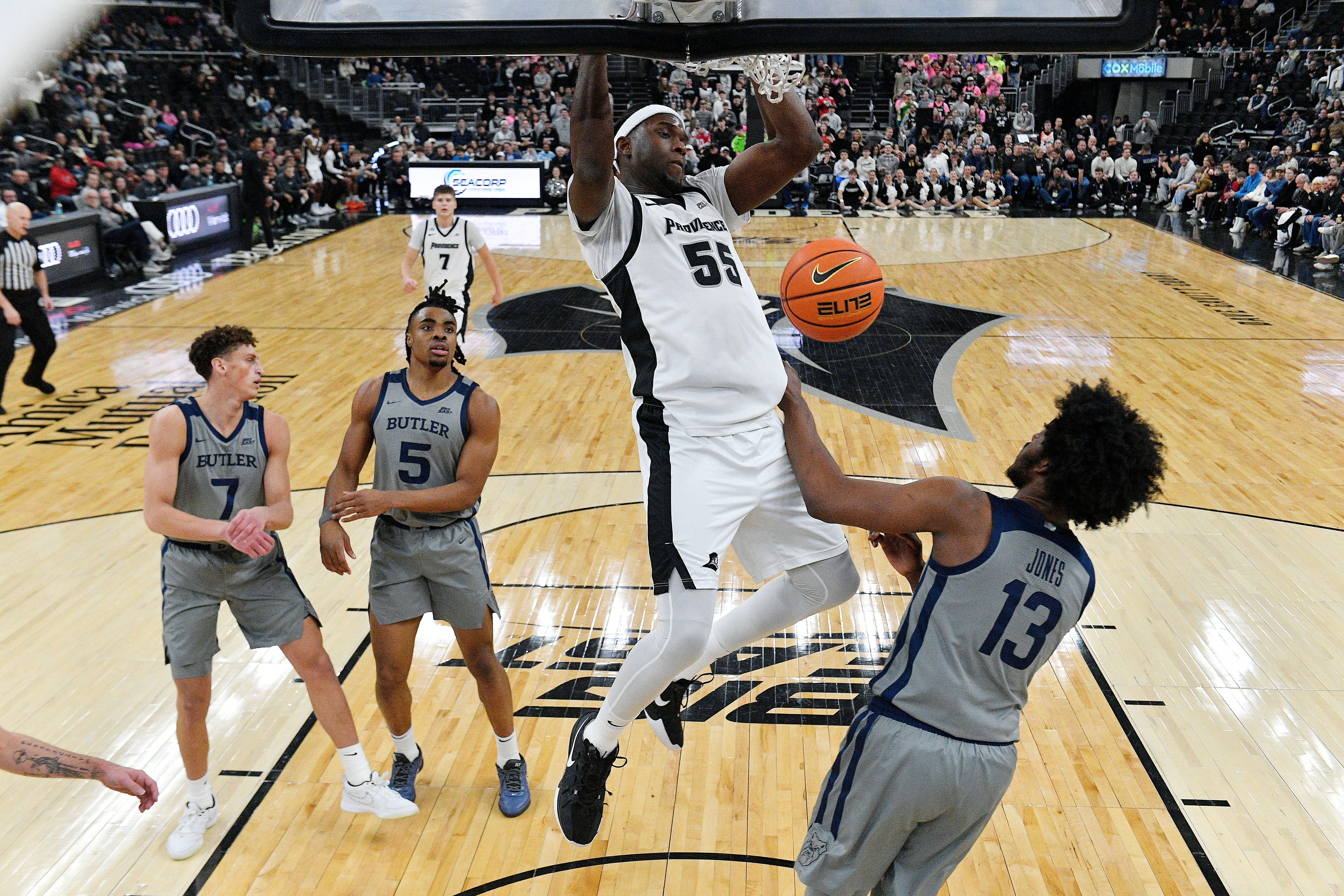 Feb 4, 2026; Providence, Rhode Island, USA; Providence Friars forward Oswin Erhunmwunse (55) hangs from the rim after dunking the ball against the Butler Bulldogs during the first half at Amica Mutual Pavilion. Mandatory Credit: Eric Canha-Imagn Images