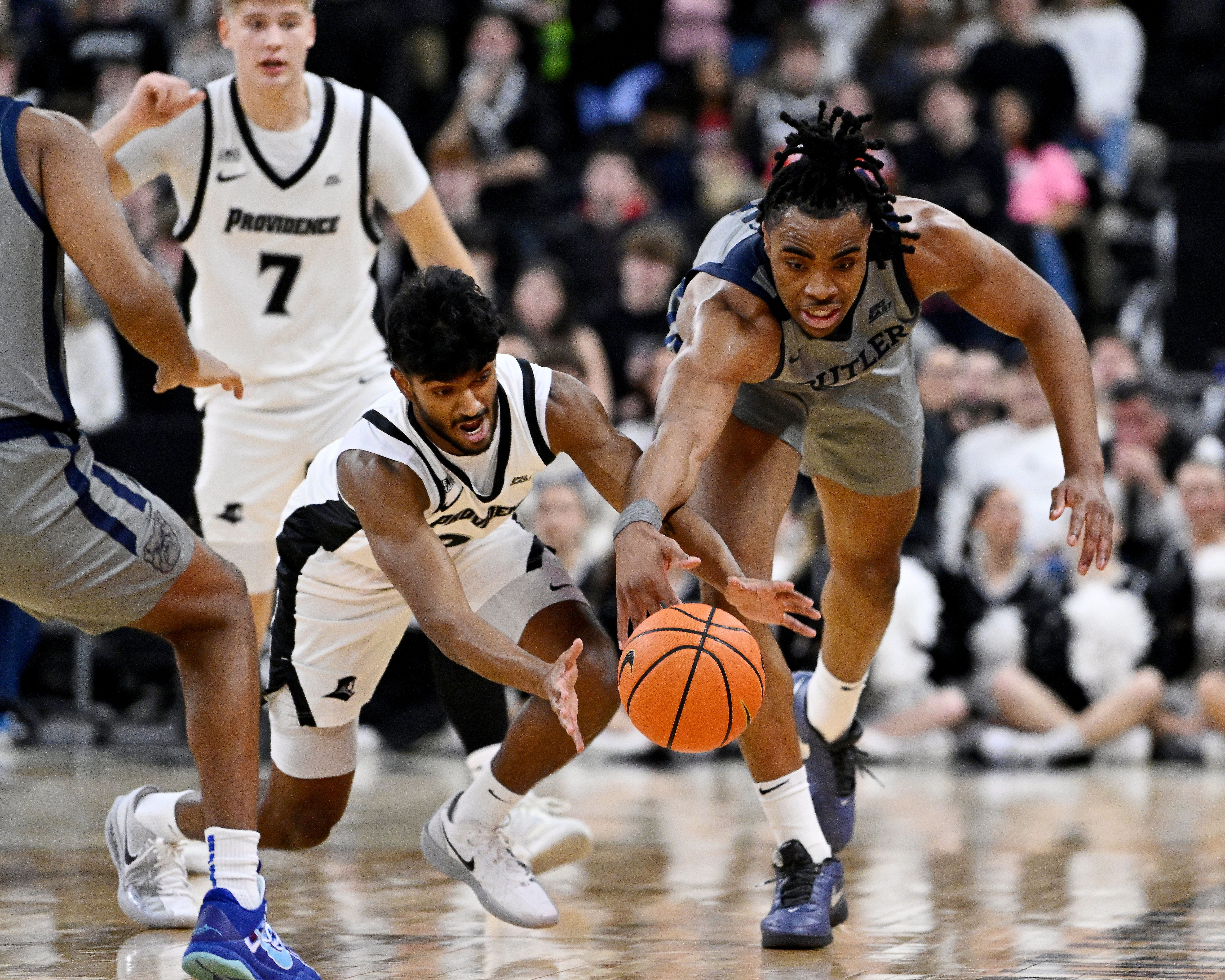 Feb 4, 2026; Providence, Rhode Island, USA; Providence Friars guard Nilavan Daniels (20) and Butler Bulldogs forward Michael Ajayi (5) race for the loose ball during the first half at Amica Mutual Pavilion. Mandatory Credit: Eric Canha-Imagn Images