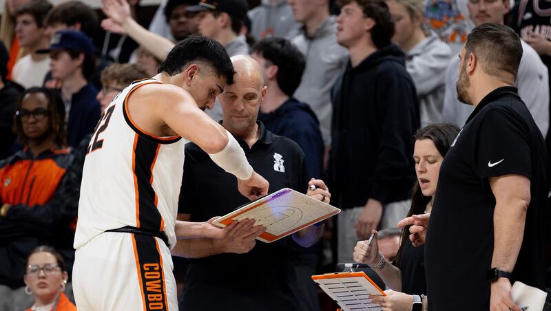 Oklahoma State head coach Steve Lutz talks with Oklahoma State center Parsa Fallah (22) in the first half of an NCAA college basketball game against BYU, Wednesday, Feb. 4, 2026 in Stillwater, Okla.