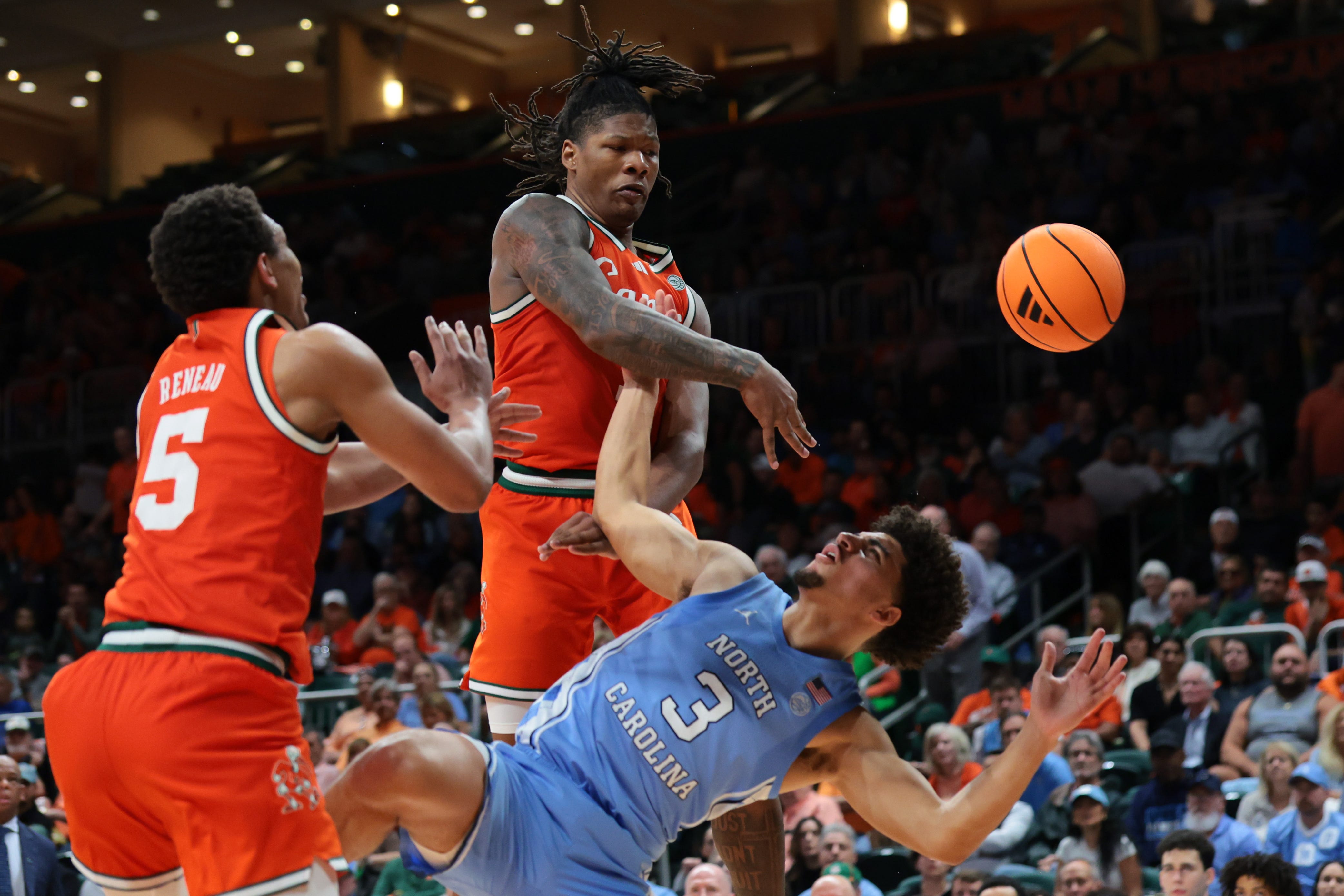 Feb 10, 2026; Coral Gables, Florida, USA; Miami Hurricanes forward Shelton Henderson (7) blocks a shot against North Carolina Tar Heels guard Derek Dixon (3) during the second half at Watsco Center. Mandatory Credit: Sam Navarro-Imagn Images