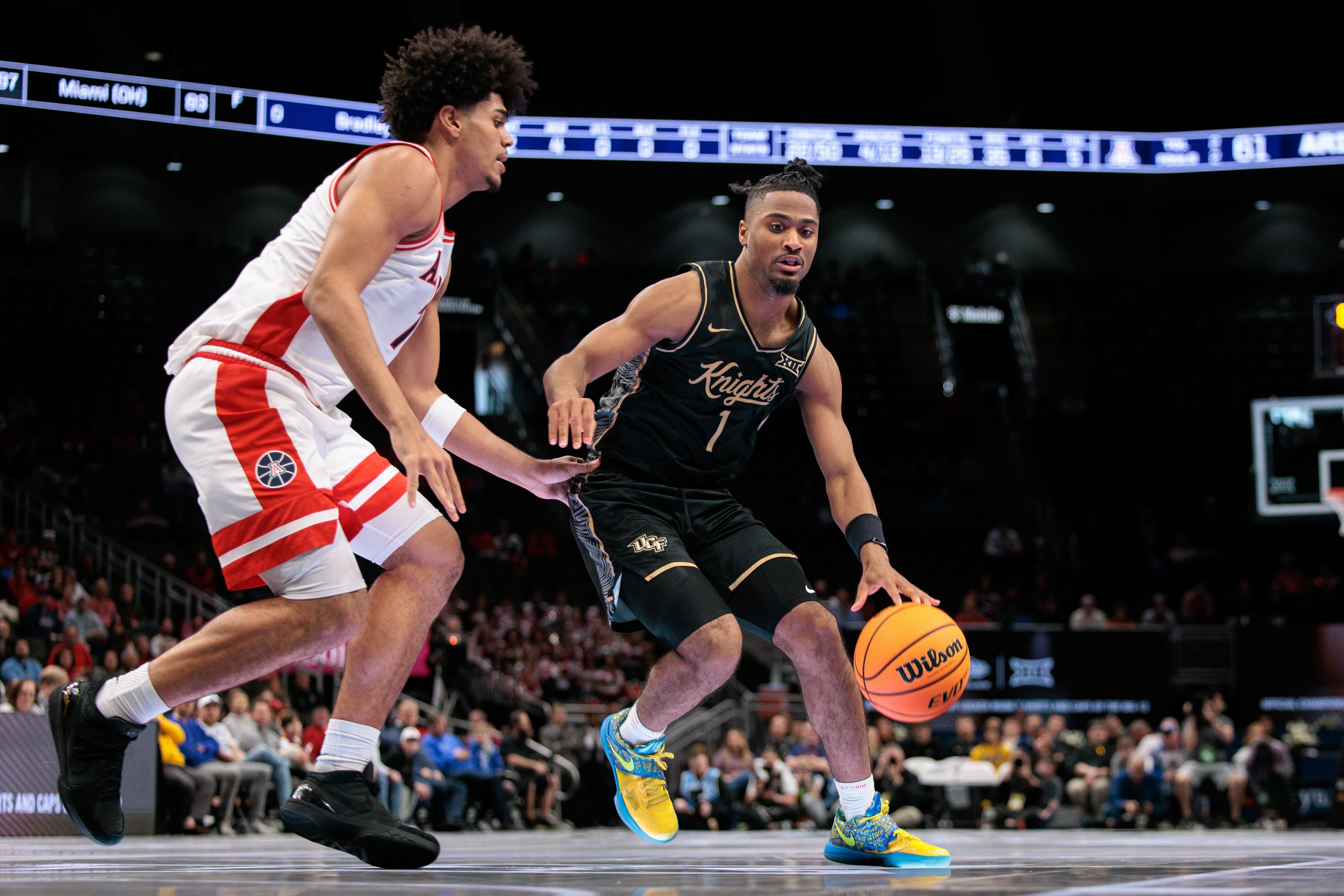 Mar 12, 2026; Kansas City, MO, USA; UCF Knights guard Themus Fulks (1) drives around Arizona Wildcats guard Jackson Francois (7) during the second half at T-Mobile Center. Mandatory Credit: William Purnell-Imagn Images