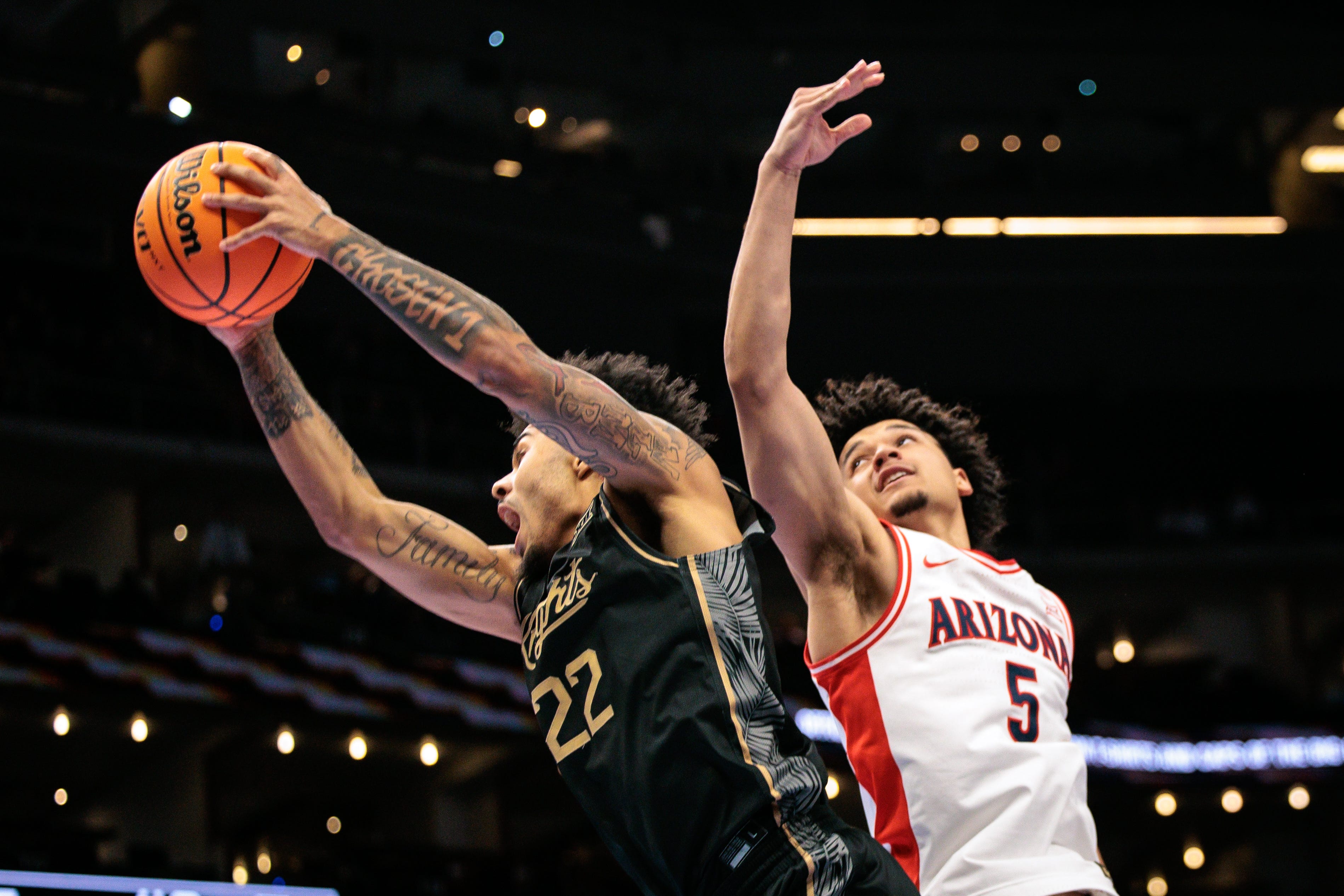 Mar 12, 2026; Kansas City, MO, USA; Arizona Wildcats guard Brayden Burries (5) and UCF Knights guard Chris Johnson (22) go after a rebound during the second half at T-Mobile Center. Mandatory Credit: William Purnell-Imagn Images