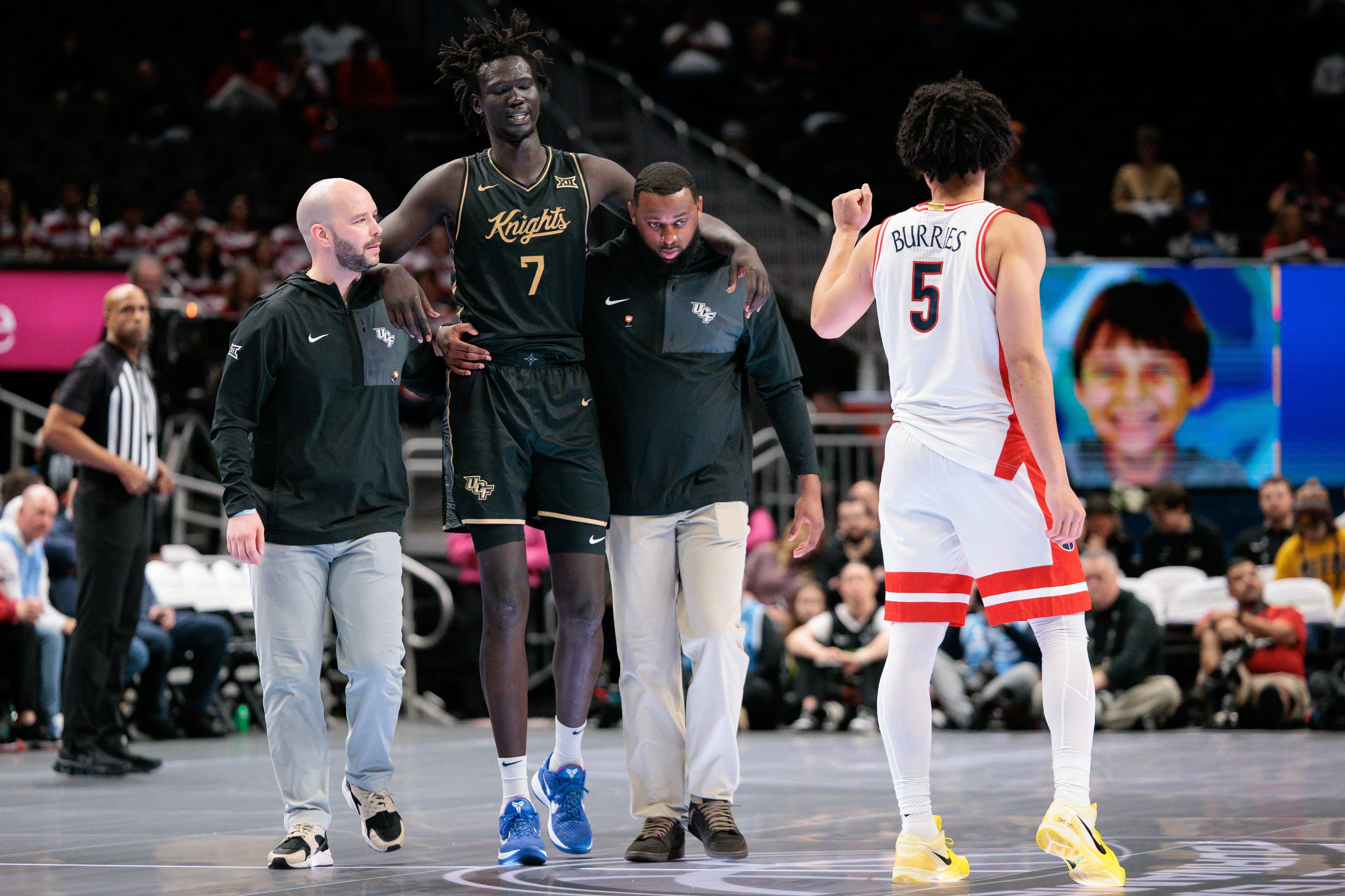 Mar 12, 2026; Kansas City, MO, USA; UCF Knights center John Bol (7) is helped off the court after an injury during the second half against the Arizona Wildcats at T-Mobile Center. Mandatory Credit: William Purnell-Imagn Images
