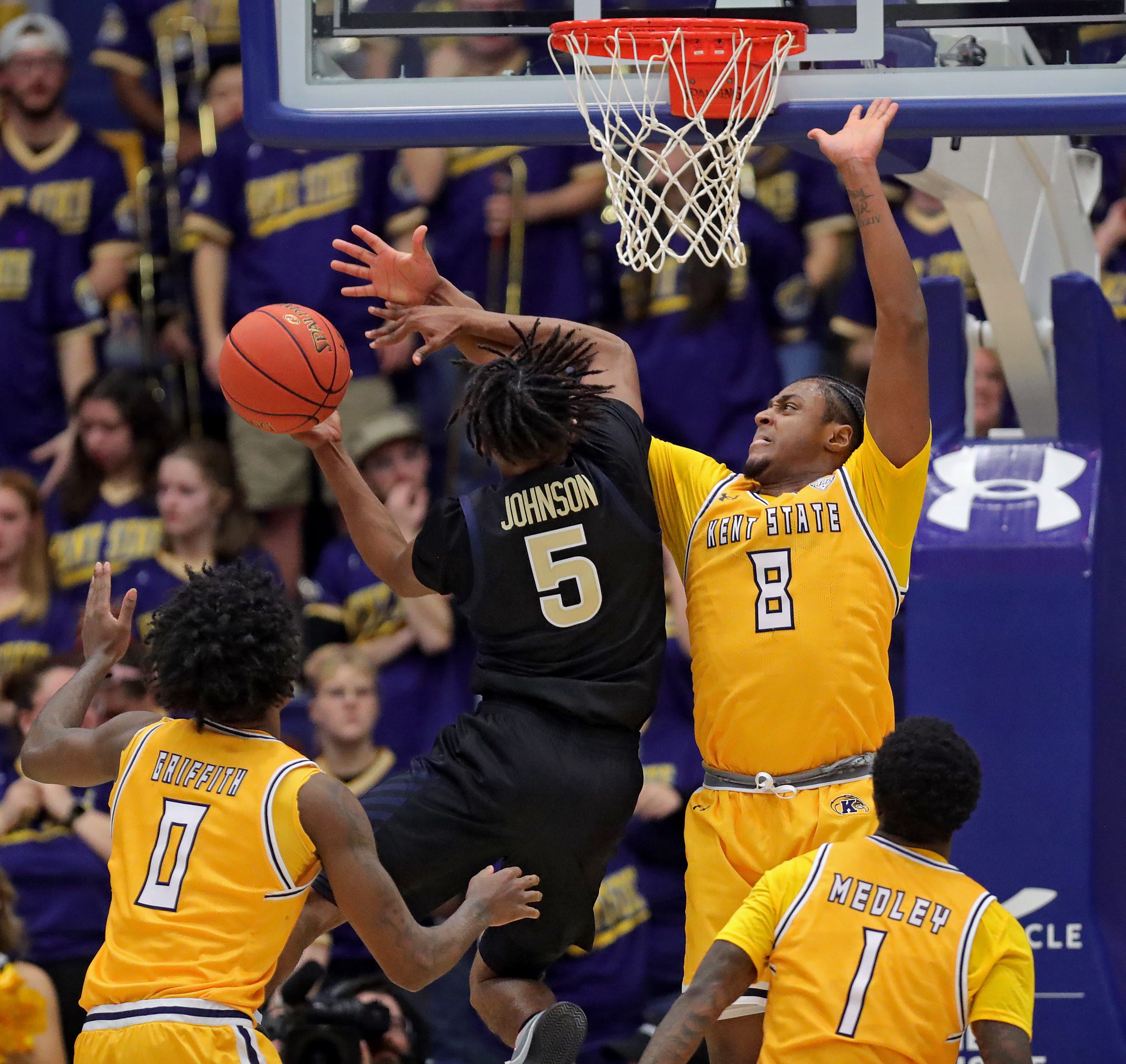 Akron Zips guard Tavari Johnson (5) is fouled by Kent State Golden Flashes guard Morgan Safford (8) on his way to the basket during the second half of an NCAA college basketball game at the M.A.C. Center, Feb. 27, 2026, in Kent, Ohio.