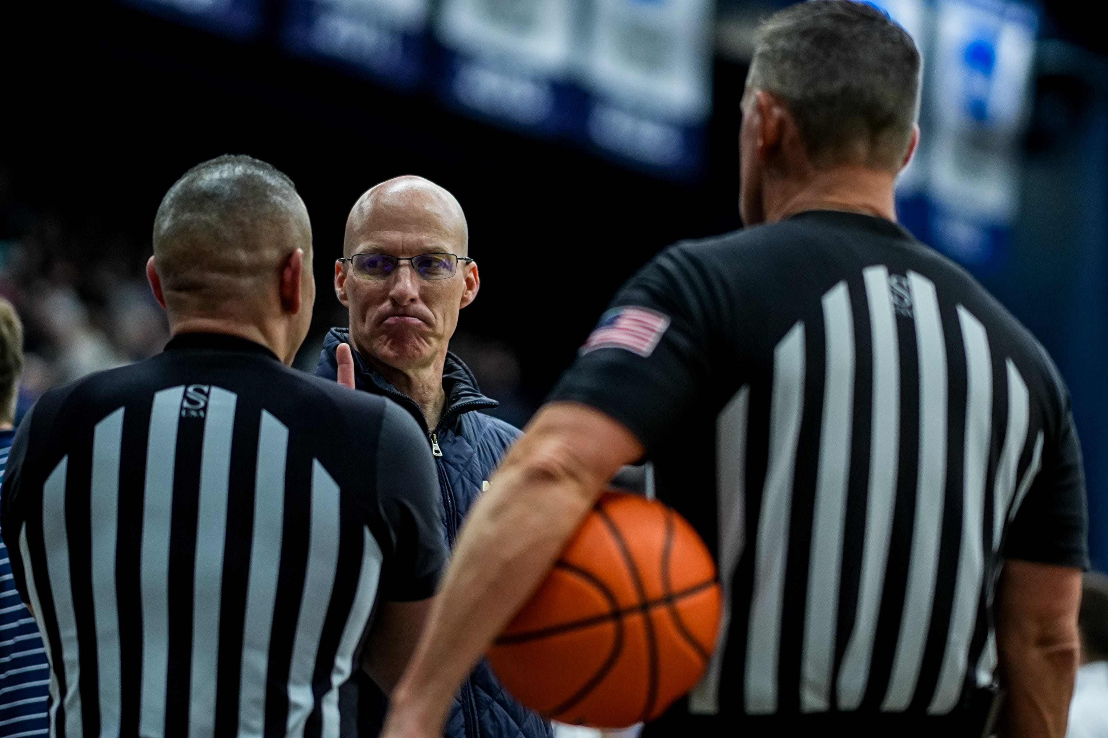 Akron Zips men's basketball coach John Groce exchanges friendly words with officials during a game against Northern Illinois on March 6, 2026, in Akron.