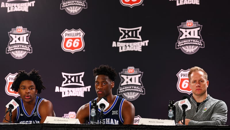 From left, BYU guard Robert Wright III (1), forward AJ Dybantsa (3) and head coach Kevin Young look on during a press conference after losing to Houston Cougars 73-66 in quarterfinals of the 2026 Phillips 66 Big 12 Men's Basketball Tournament at the T-Mobile Center in Kansas City, Missouri, on Thursday, March 12, 2026.