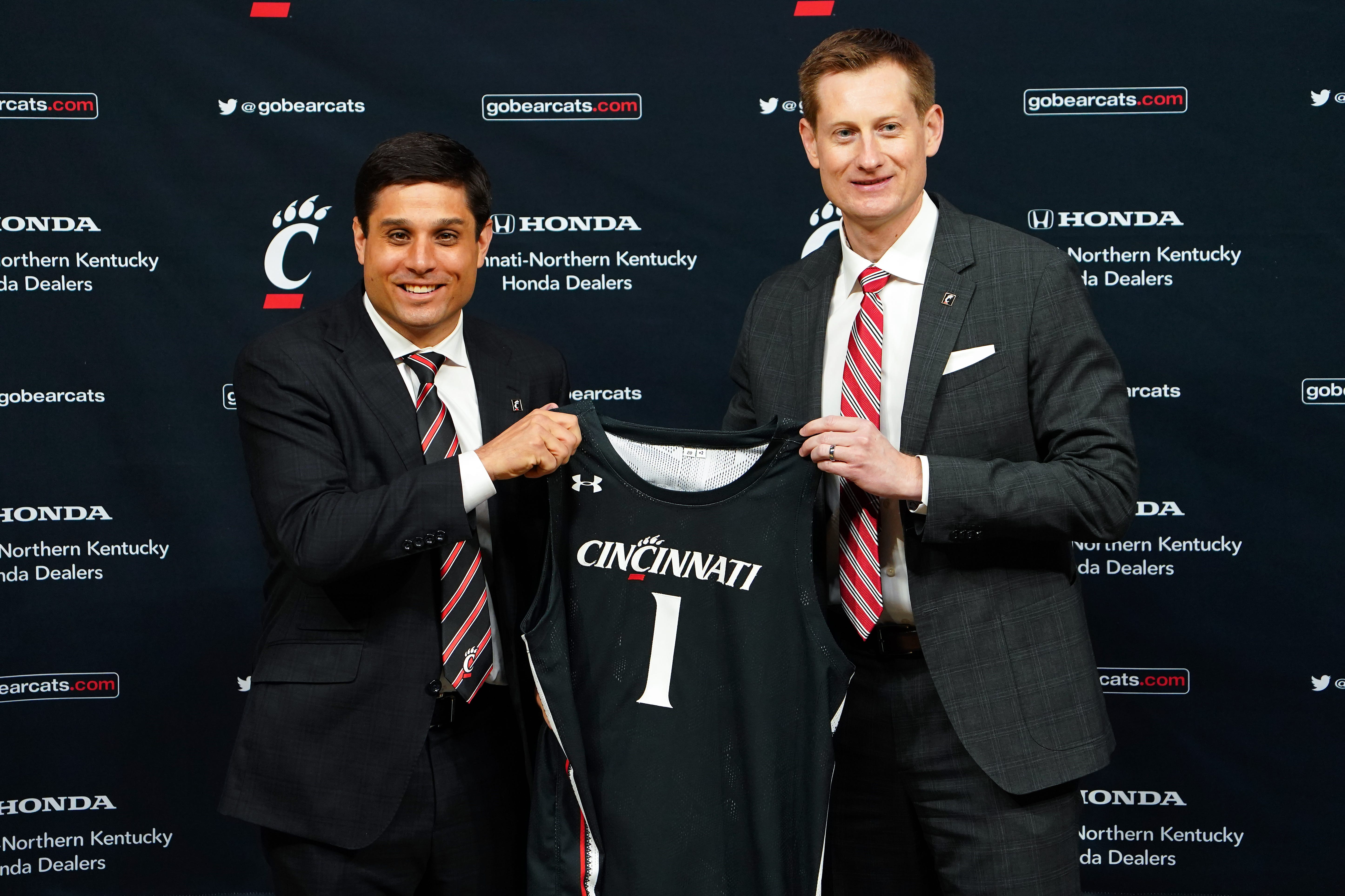 Wes Miller, left, is introduced as the new head men's basketball coach by University of Cincinnati Director of Athletics John Cunningham, April 16, 2021, at Fifth Third Arena in Cincinnati. Miller came to UC from the UNC-Greensboro where he made two NCAA tournaments.