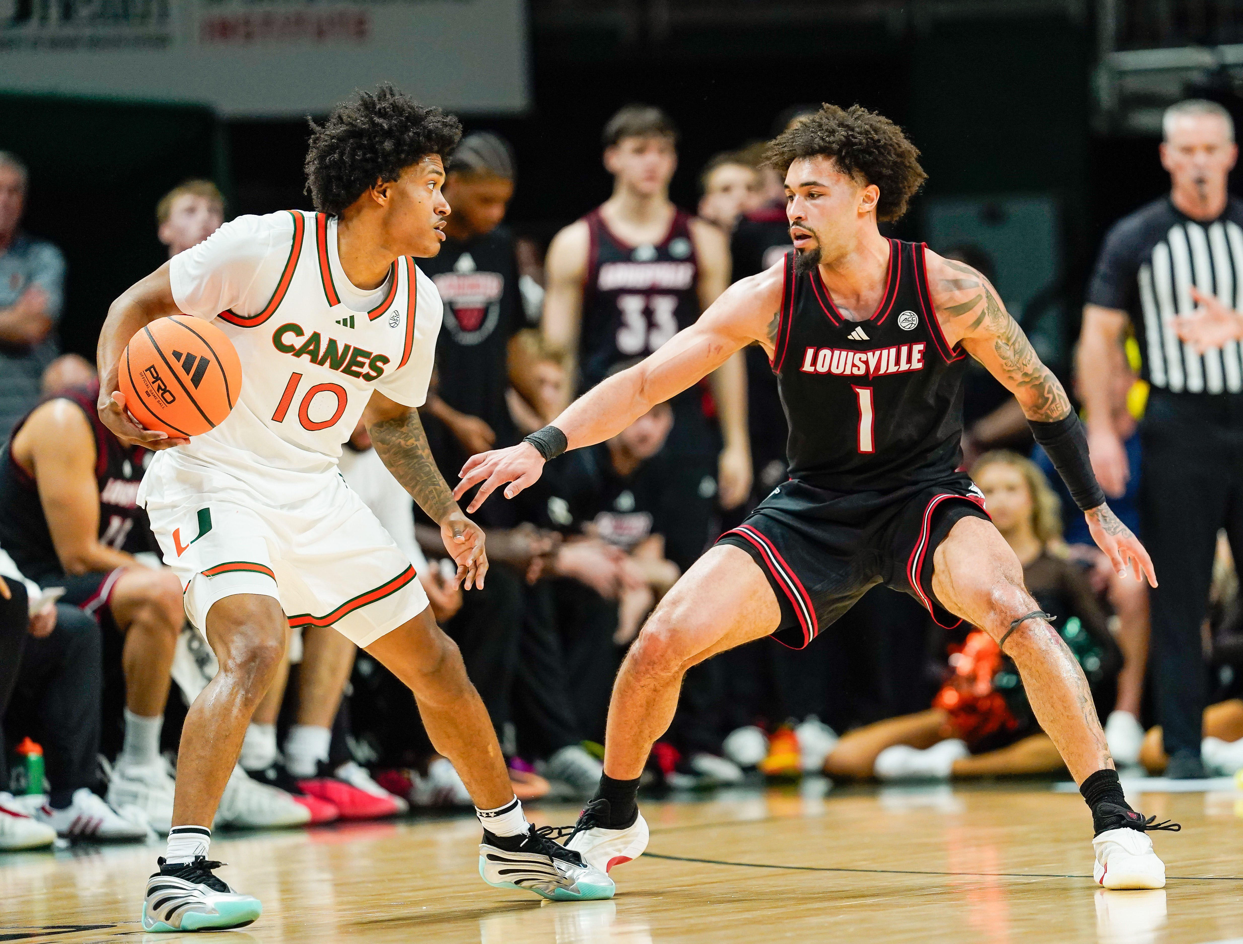 Mar 7, 2026; Coral Gables, Florida, USA; Miami Hurricanes guard Tru Washington (10) dribbles the ball against Louisville Cardinals guard J'vonne Hadley (1) during the second half at Watsco Center. Mandatory Credit: Jeff Romance-Imagn Images