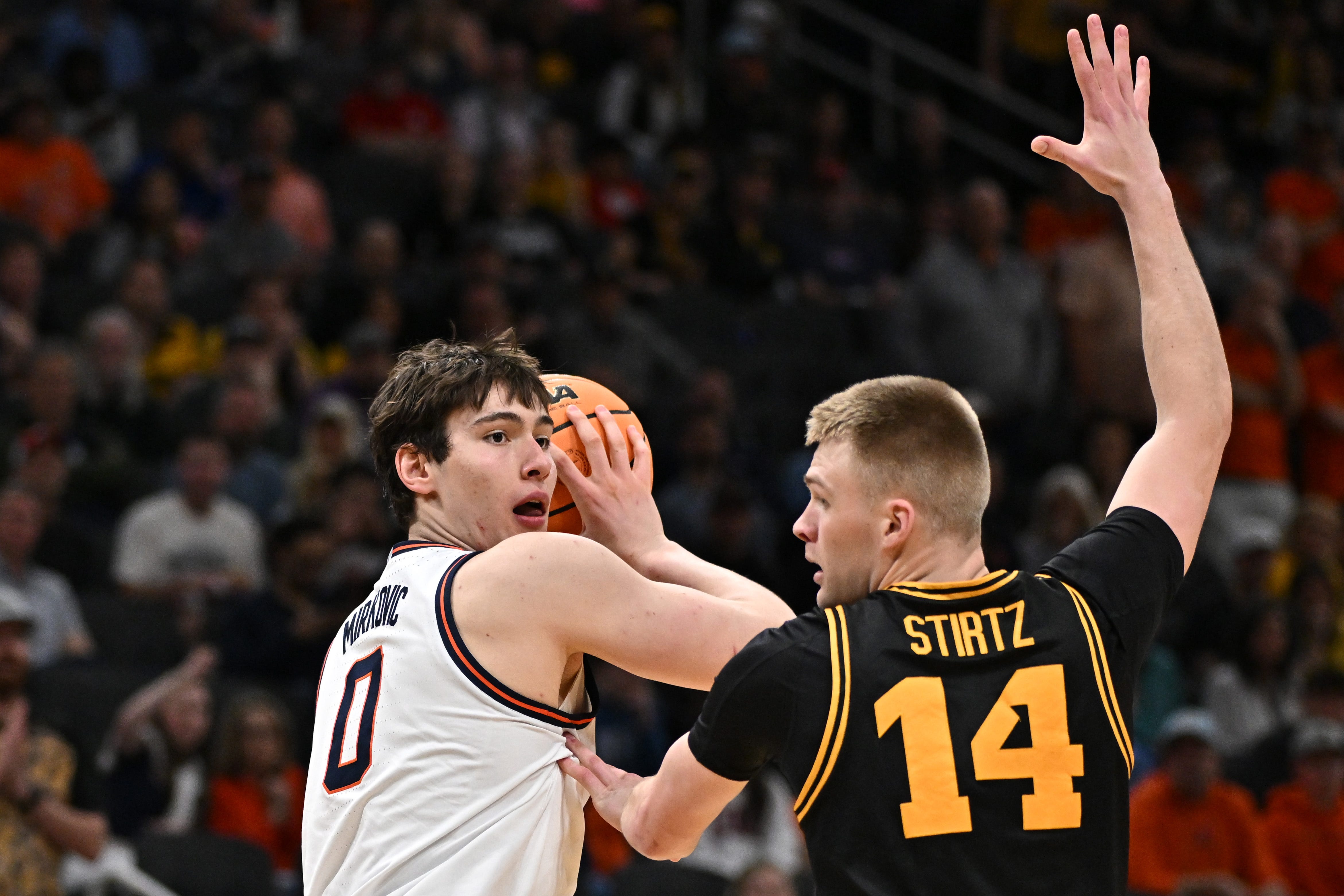 Illinois Fighting Illini forward David Mirkovic (0) controls the ball against Iowa Hawkeyes guard Bennett Stirtz (14) in the second half during an Elite Eight game of the South Region of the men's 2026 NCAA Tournament at Toyota Center.