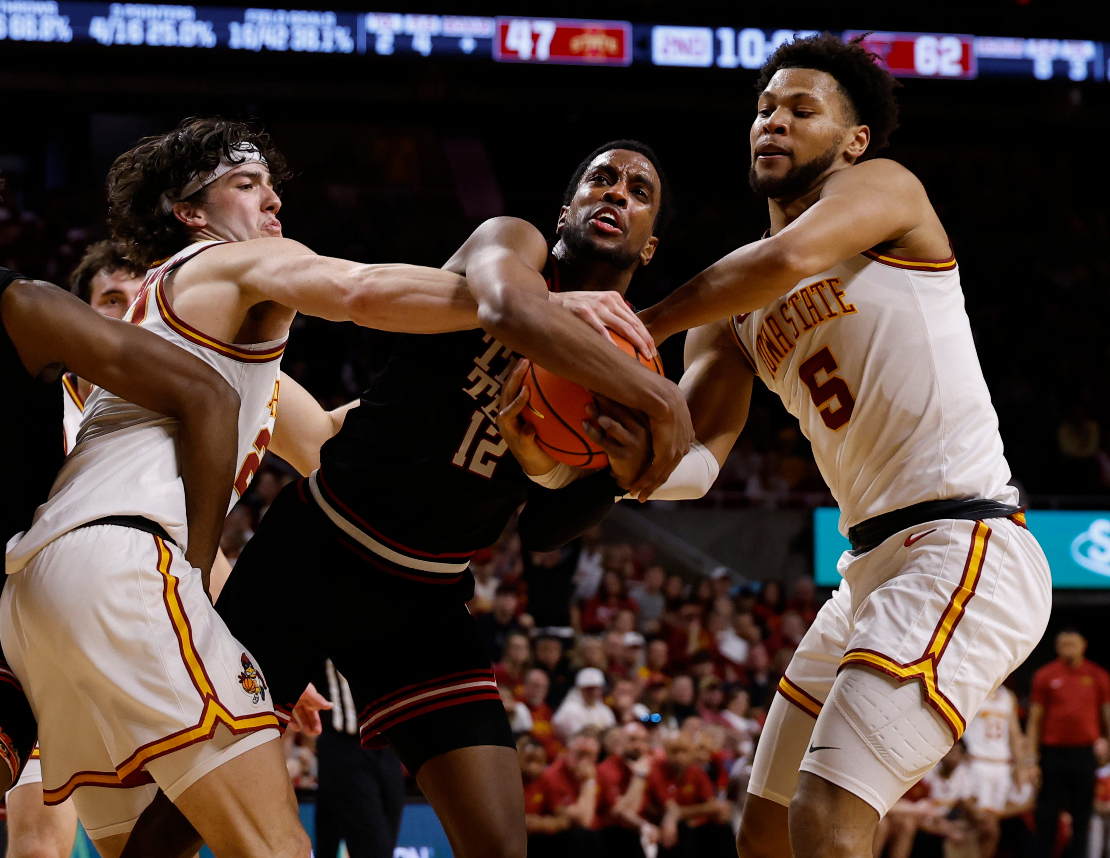 AMES, IA - FEBRUARY 28: Donovan Atwell #12 of the Texas Tech Red Raiders battles for the ball as Blake Buchanan #23, and Joshua Jefferson #5 of the Iowa State Cyclones defend in the second half of play at Hilton Coliseum on February 28, 2026 in Ames, Iowa. The Texas Tech Red Raiders won 82-73 over the Iowa State Cyclones. (Photo by David Purdy/Getty Images)