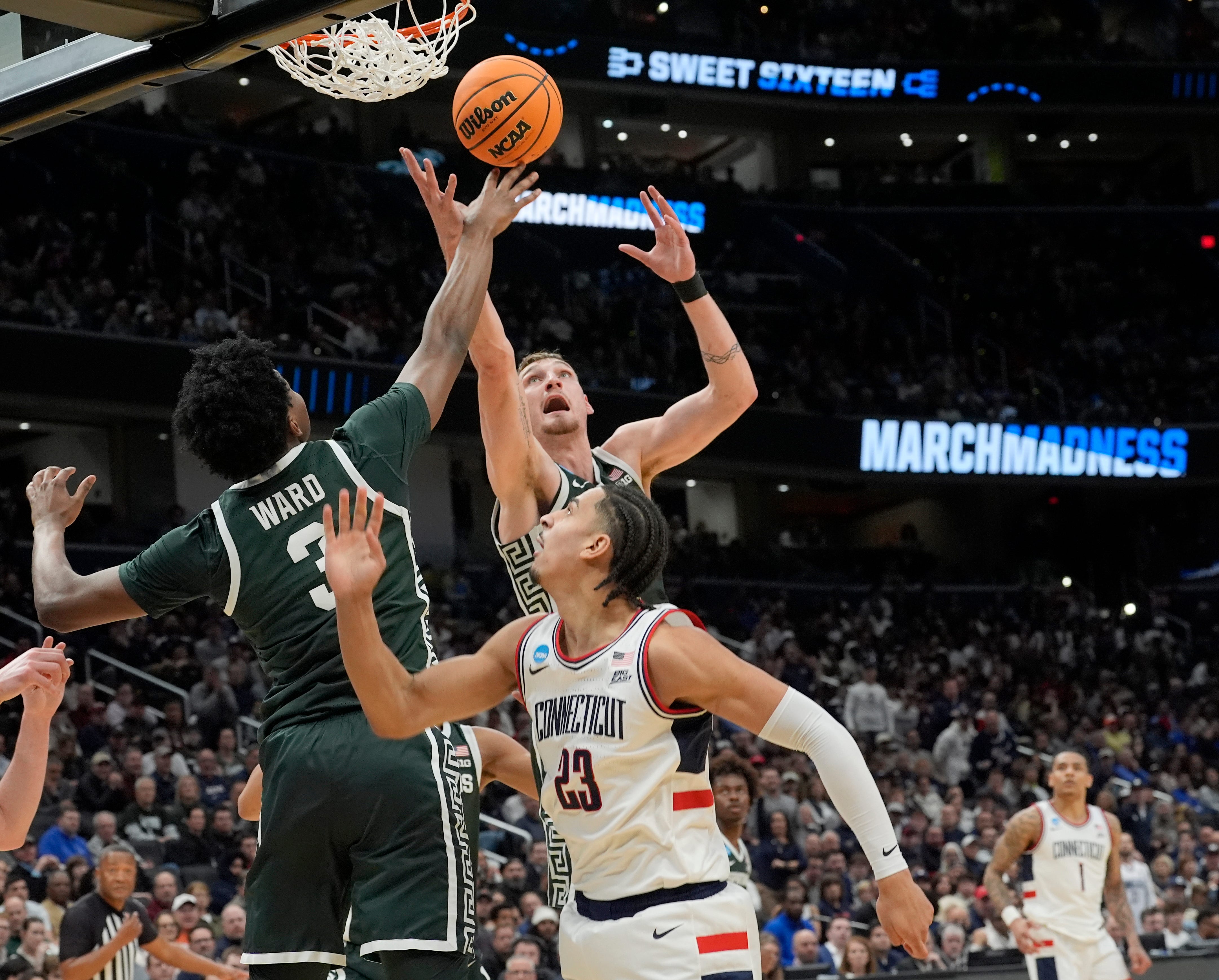 Michigan State forward Cameron Ward (3) and Michigan State center Carson Cooper (15) go up for the defense rebound over Connecticut forward Jayden Ross (23) during the first half of the 2026 NCAA Men's Basketball East Regional game against UConn at Capital One Arena in Washington DC on Friday, March 27, 2026.