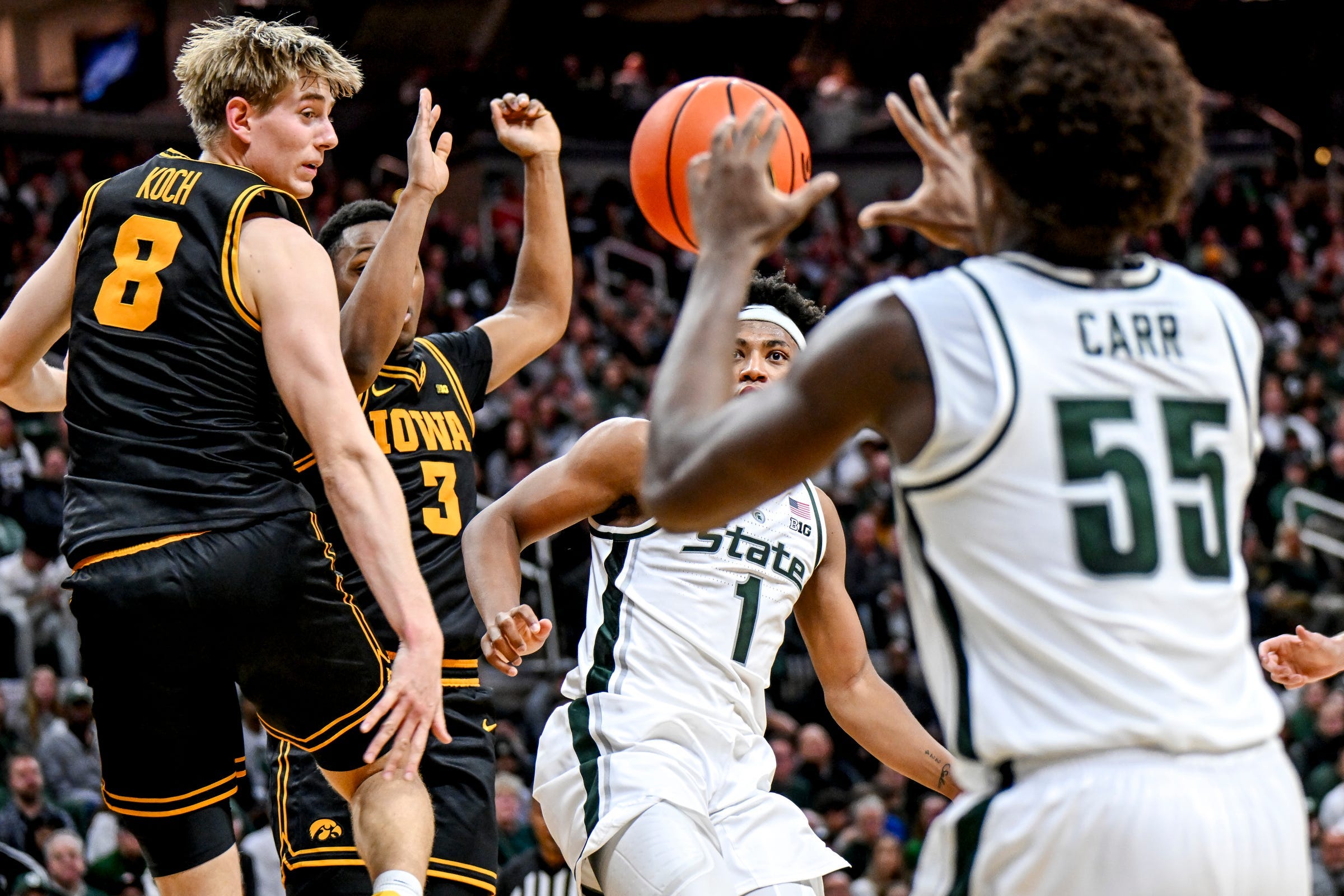Michigan State's Jeremy Fears Jr., center, watches his assist to Coen Carr, right, against Iowa during the first half on Tuesday, Dec. 2, 2025, at the Breslin Center in East Lansing.