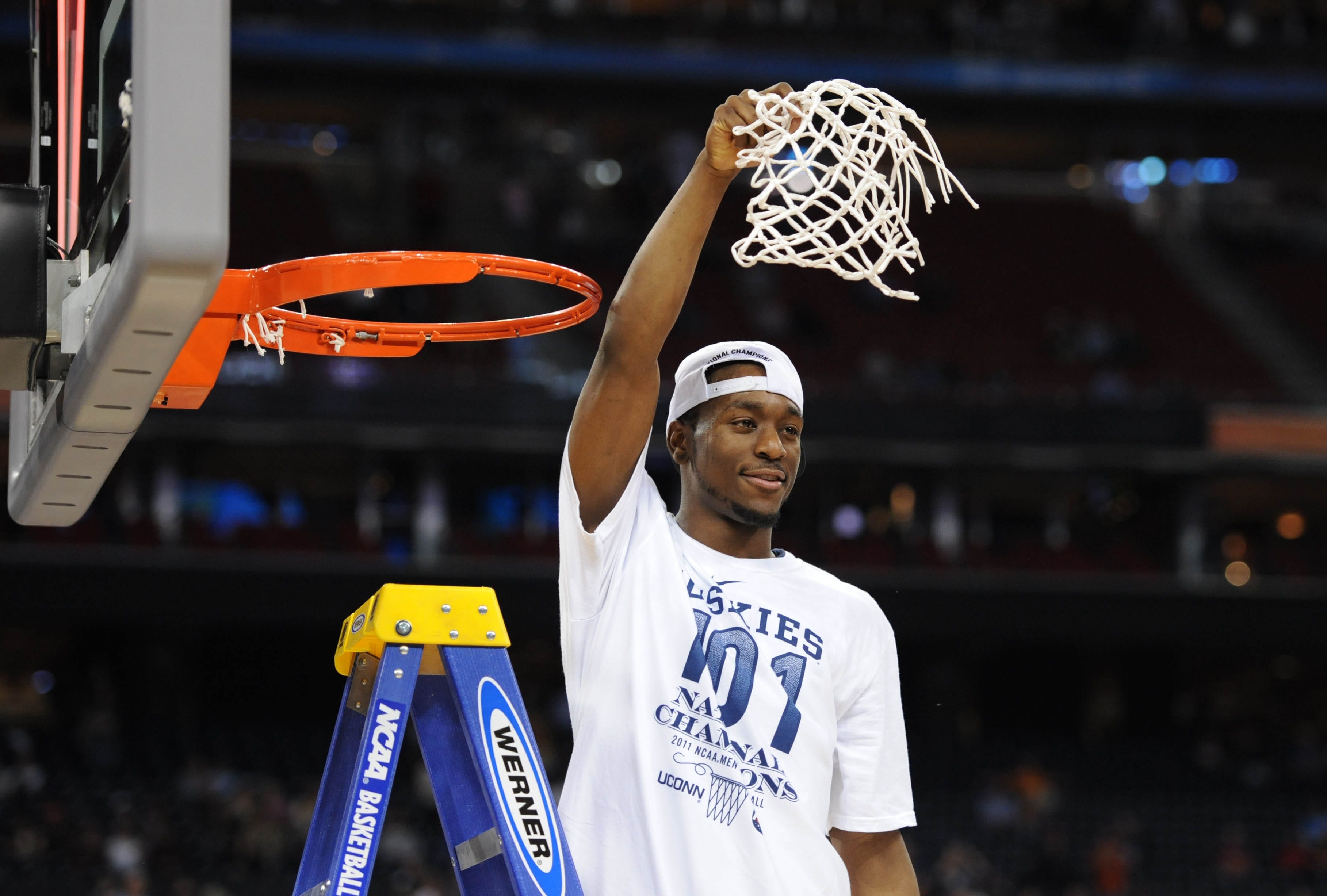 Connecticut Huskies guard Kemba Walker waves to the crowd after cutting down the net.
