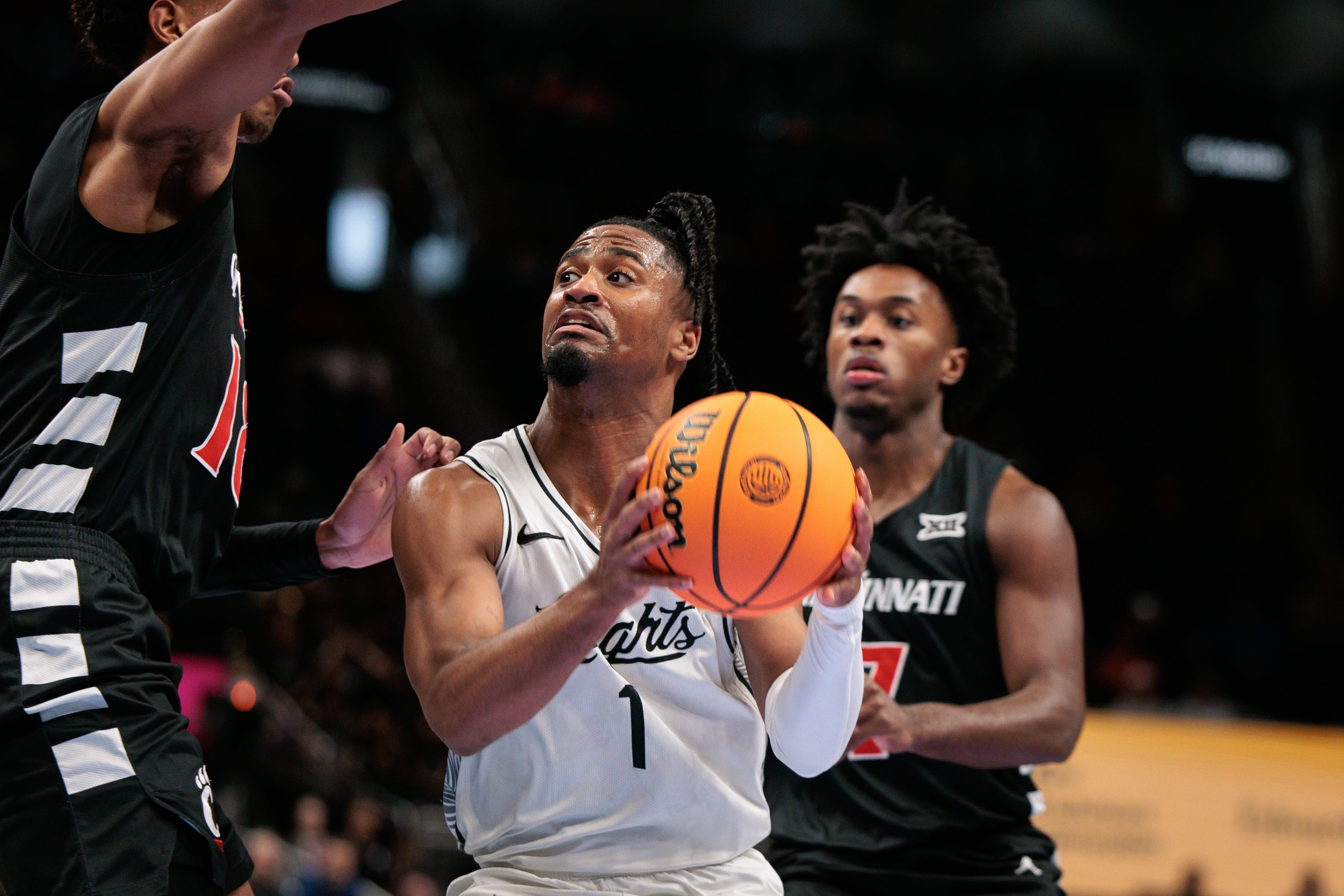 Mar 11, 2026; Kansas City, MO, USA; UCF Knights guard Themus Fulks (1) drives to the basket around Cincinnati Bearcats forward Baba Miller (18) during the first half at T-Mobile Center. Mandatory Credit: William Purnell-Imagn Images