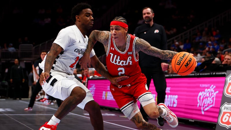 Utah guard Terrence Brown, right, drives past Cincinnati guard Jizzle James during  the 2026 Phillips 66 Big 12 Men's Basketball Tournament at the T-Mobile Center in Kansas City, Mo., on Tuesday, March 10, 2026.