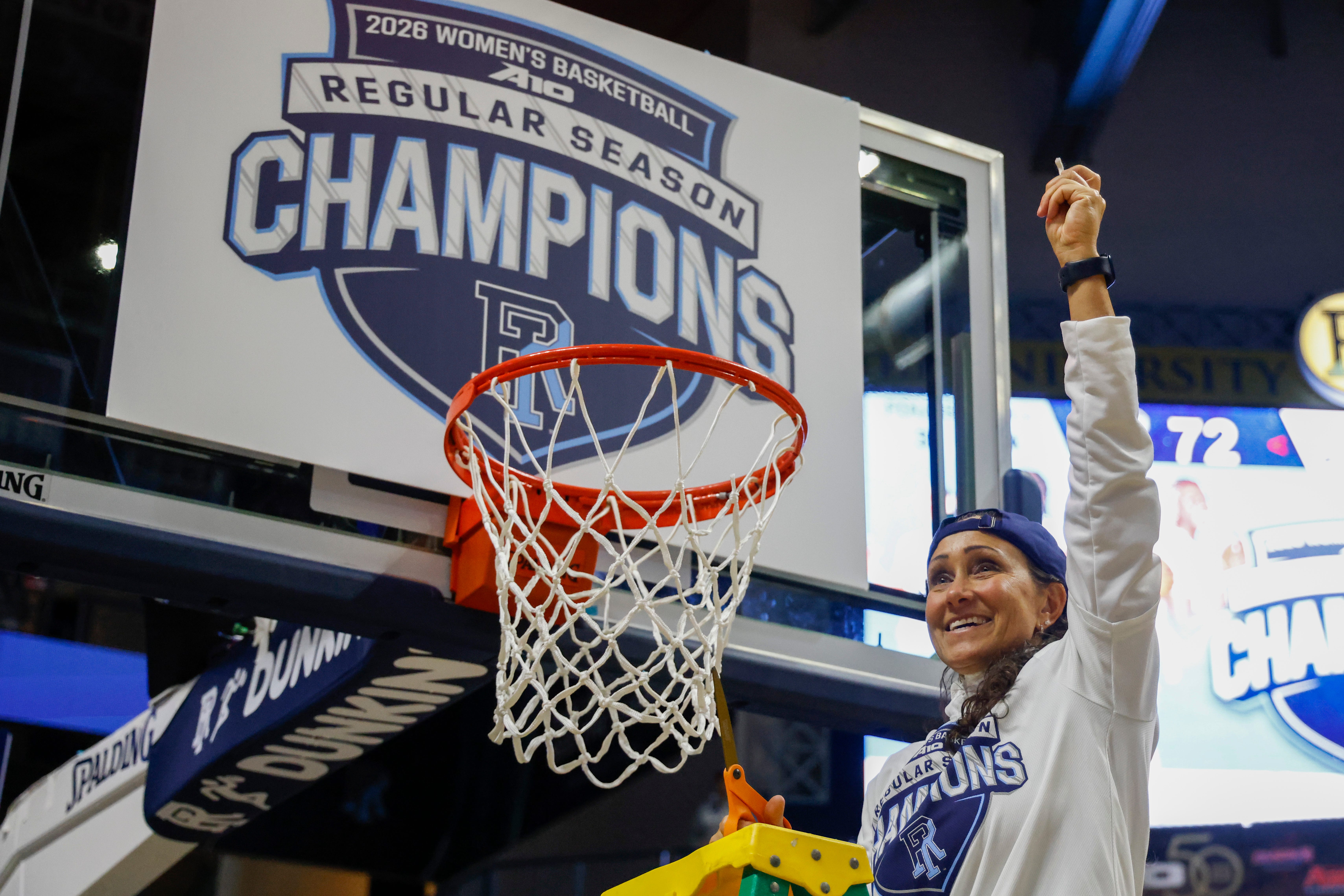 URI women's basketball coach Tammi Reiss cuts a piece of the basket for her team after the Rams beat George Washington University to clinch the Atlantic-10 regular season championship on Saturday, Feb. 28, at the Ryan Center.