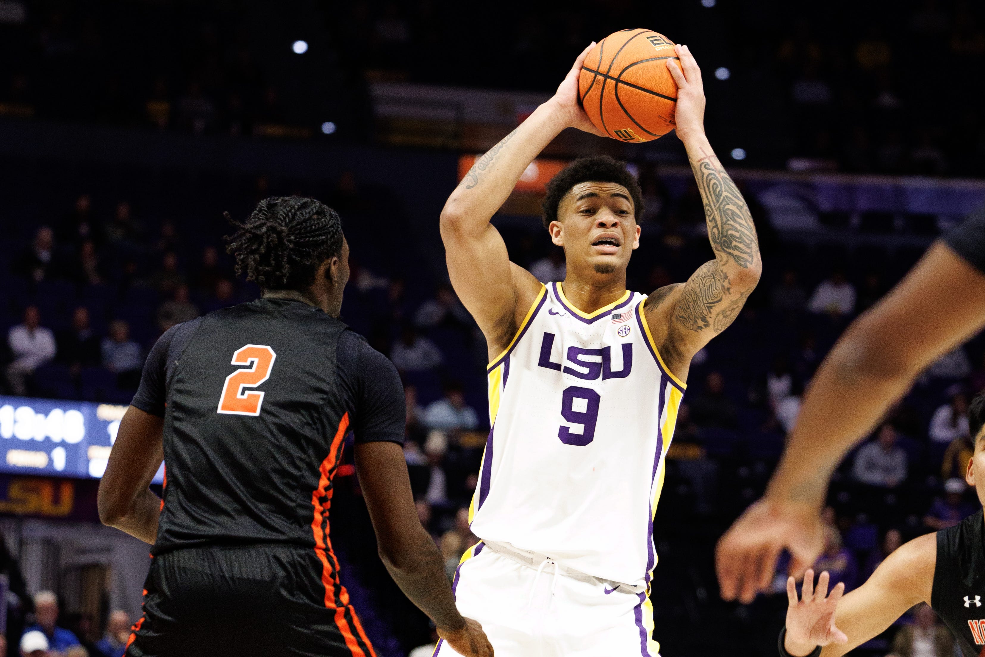 Nov 29, 2024; Baton Rouge, Louisiana, USA; LSU Tigers forward Jalen Reed (9) looks to pass the ball against Northwestern State Demons forward Jerald Colonel (2) during the first half at Pete Maravich Assembly Center. Mandatory Credit: Stephen Lew-Imagn Images