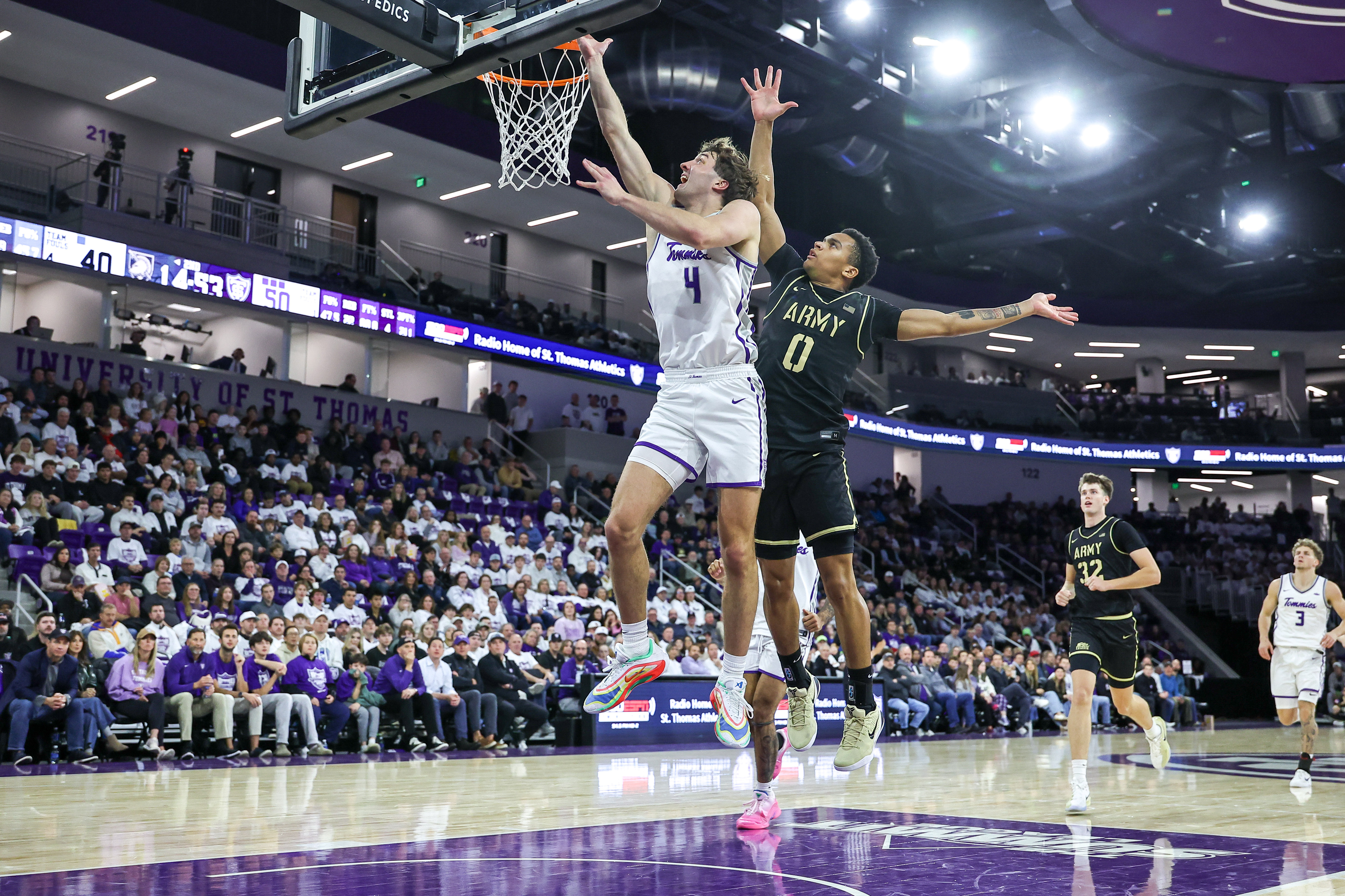 ST PAUL, MINNESOTA - NOVEMBER 8: Nolan Minessale #4 of the St. Thomas-Minnesota Tommies drives to the basket against Dayon Polk #0 of the Army Black Knights in the second half at Lee & Penny Anderson Arena on November 8, 2025 in St Paul, Minnesota. St. Thomas won 83-76 against Army Golden Knights.