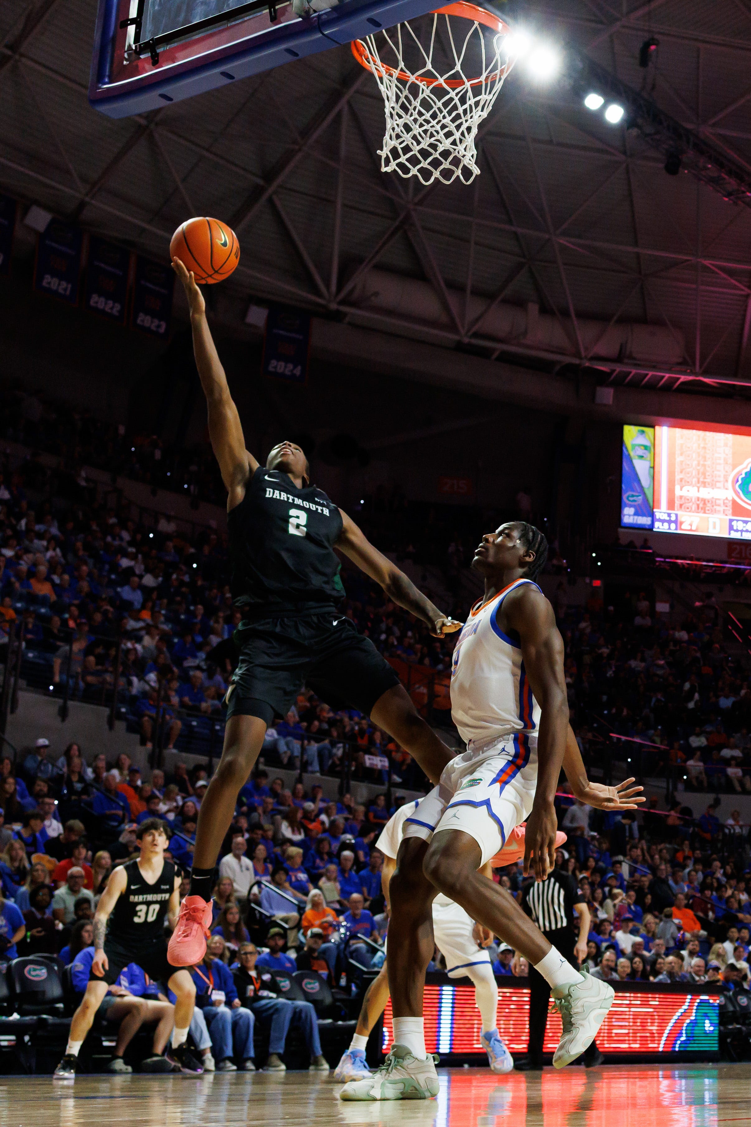 Dec 29, 2025; Gainesville, Florida, USA; Dartmouth Big Green guard Kareem Thomas (2) makes a layup over Florida Gators center Rueben Chinyelu (9) during the second half at Exactech Arena at the Stephen C. O'Connell Center. Mandatory Credit: Matt Pendleton-Imagn Images