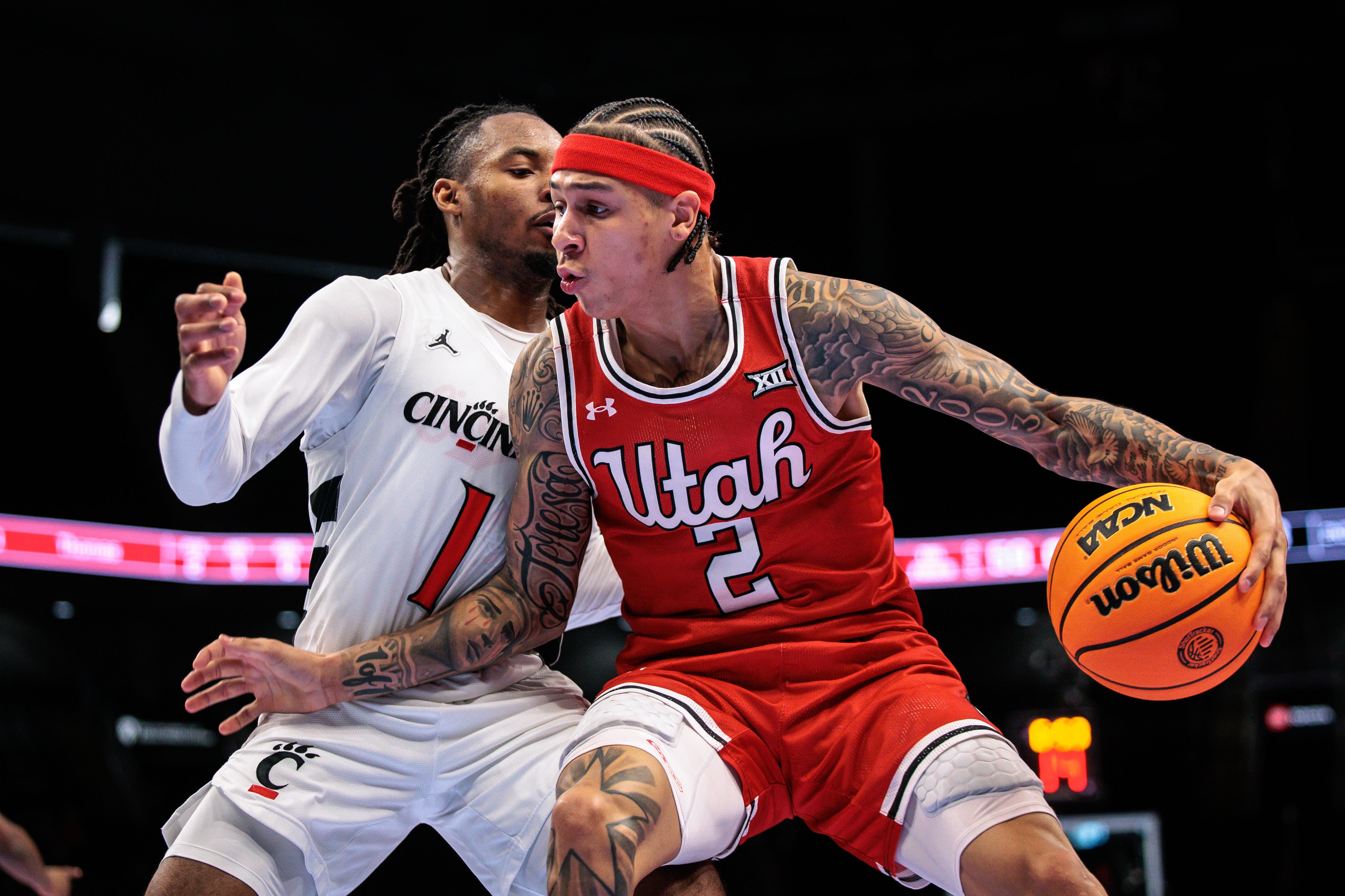 Mar 10, 2026; Kansas City, MO, USA; Utah Utes guard Terrence Brown (2) drives around Cincinnati Bearcats guard Day Day Thomas (1) during the second half at T-Mobile Center. Mandatory Credit: William Purnell-Imagn Images