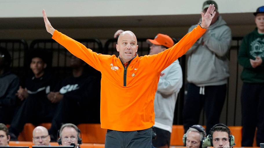 Oklahoma State coach Steve Lutz raises his hands in the air while coaching his team.
